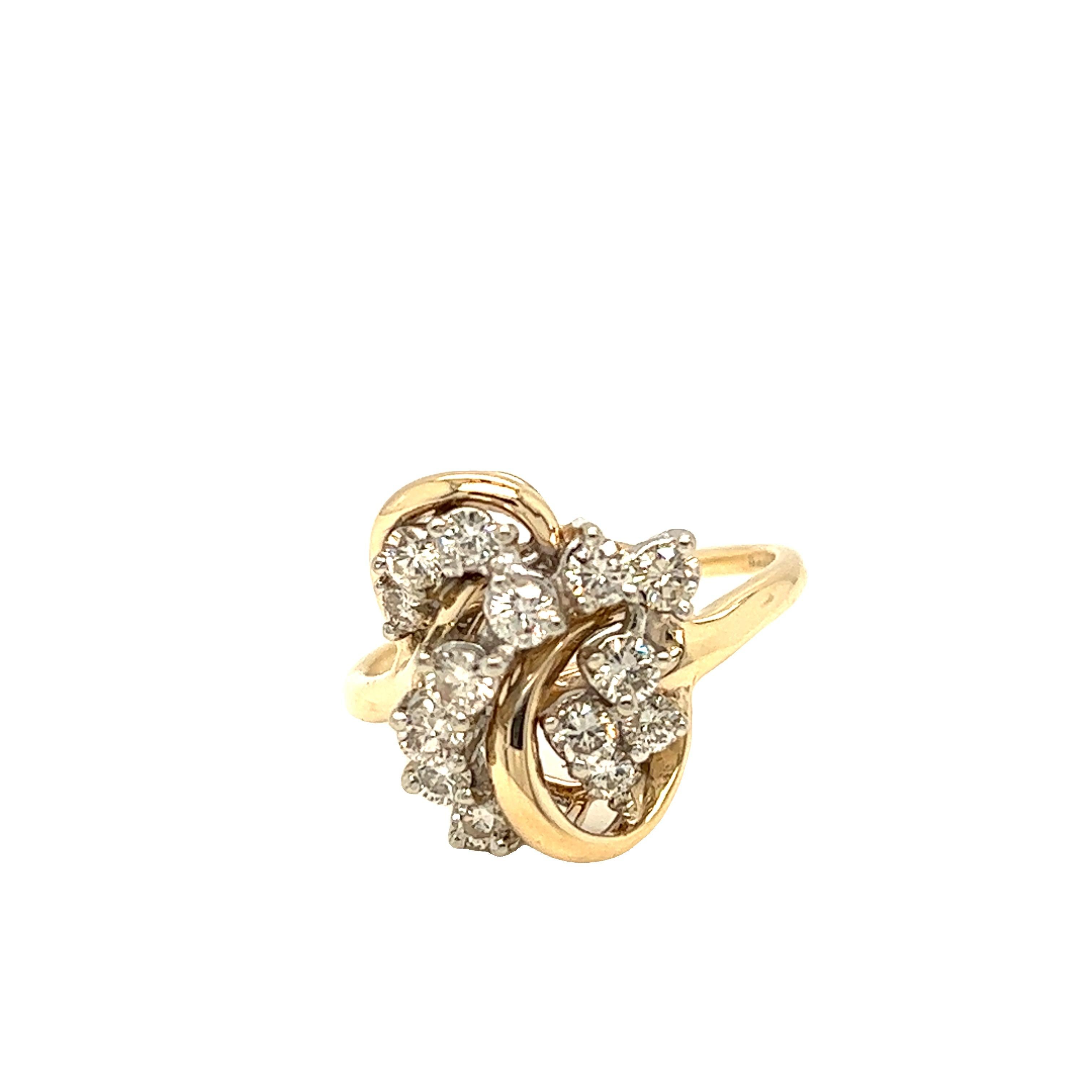 This finely crafted piece features a ribbon design with 14 diamonds weighing approximately 1.20 carat, H color and SI1 clarity. The cluster diamonds are set in 14k white gold while the rest of the ring is in 14k yellow gold. Currently in a size 8.25