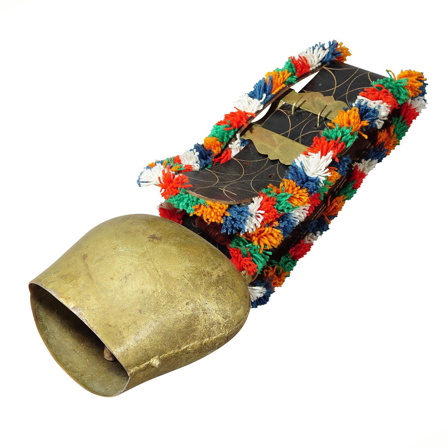 A large handforged cow bell from the Alps region of Switzerland, manufactured around 1950. The bell comes with its original brown leather strap with buckle and colorful wool decoration. These bells are used to locate cattles in the pasture. Cows