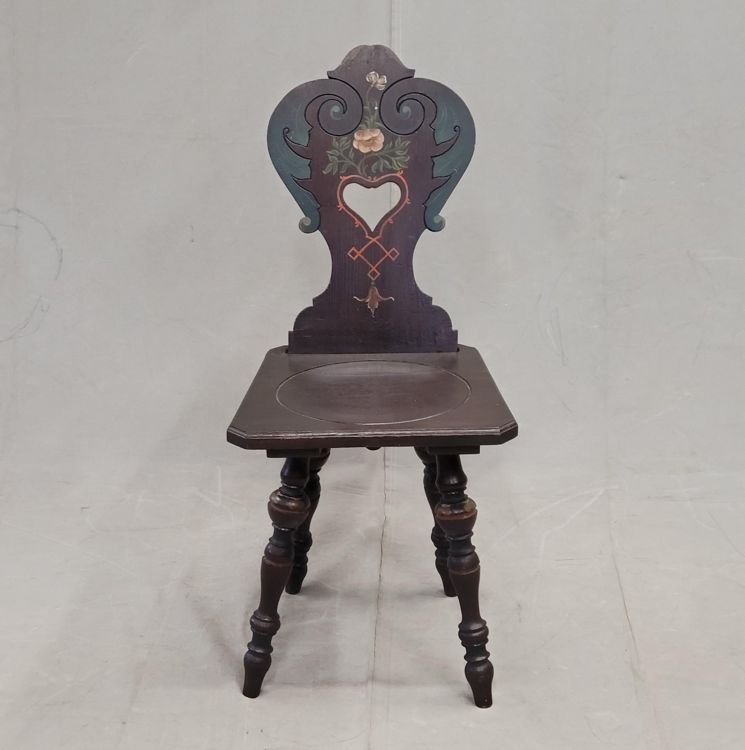 A charming vintage Swiss or southern German carved and painted board chair with turned legs. Skillfully painted and structurally strong this chair would be a sweet accent chair in a corner. A removable wedge holds the backrest to the seat