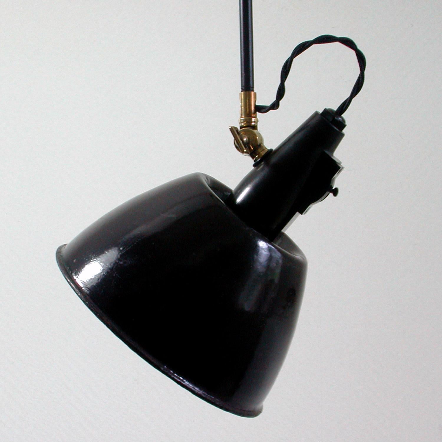 This industrial pendant was manufactured in Switzerland in the late 1920s-1930s by Belmag in Zurich. The black and white enamel lamp shade can be turned and adjusted in multiple directions using the brass joint.

The lamp has been rewired and