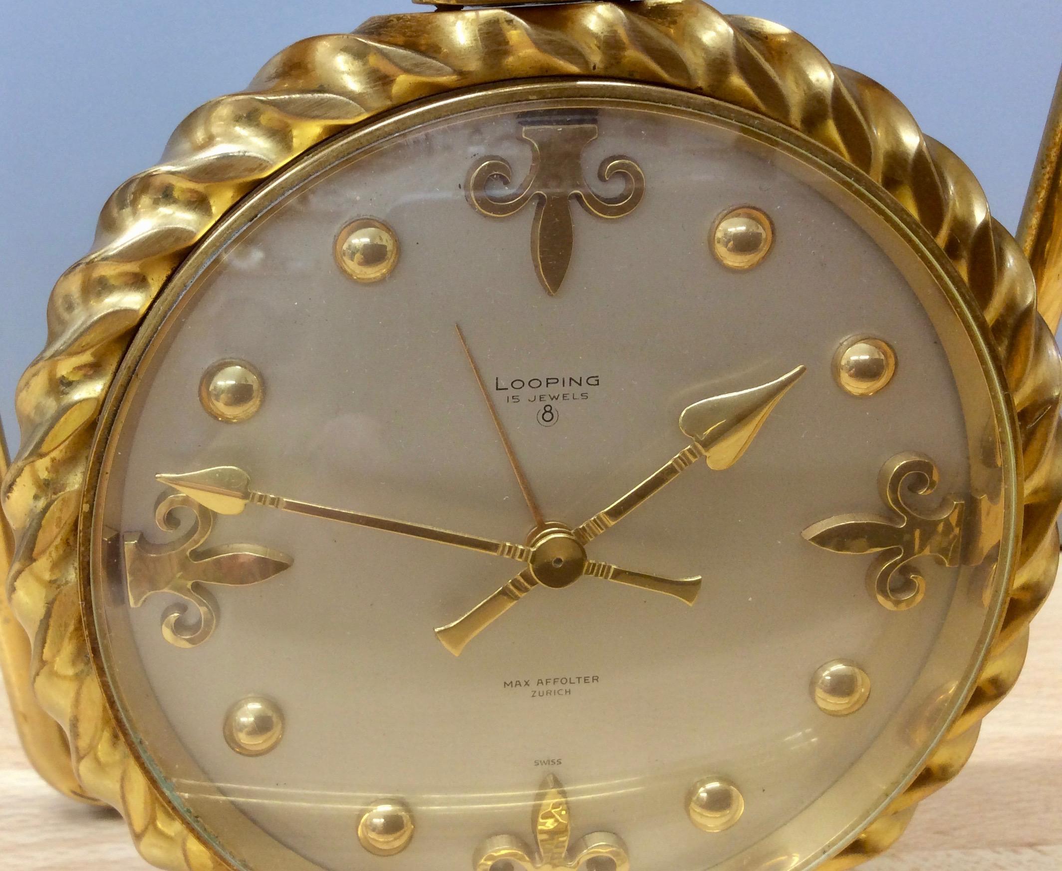 Vintage mantel clock resting within a gilded strut frame supphandsorting a circular dial surrounded by rope decoration.


Silvered dial with original gilded hands and seperate hand for the alarm.

The dial with raised, gilded, 'Dot' numerals