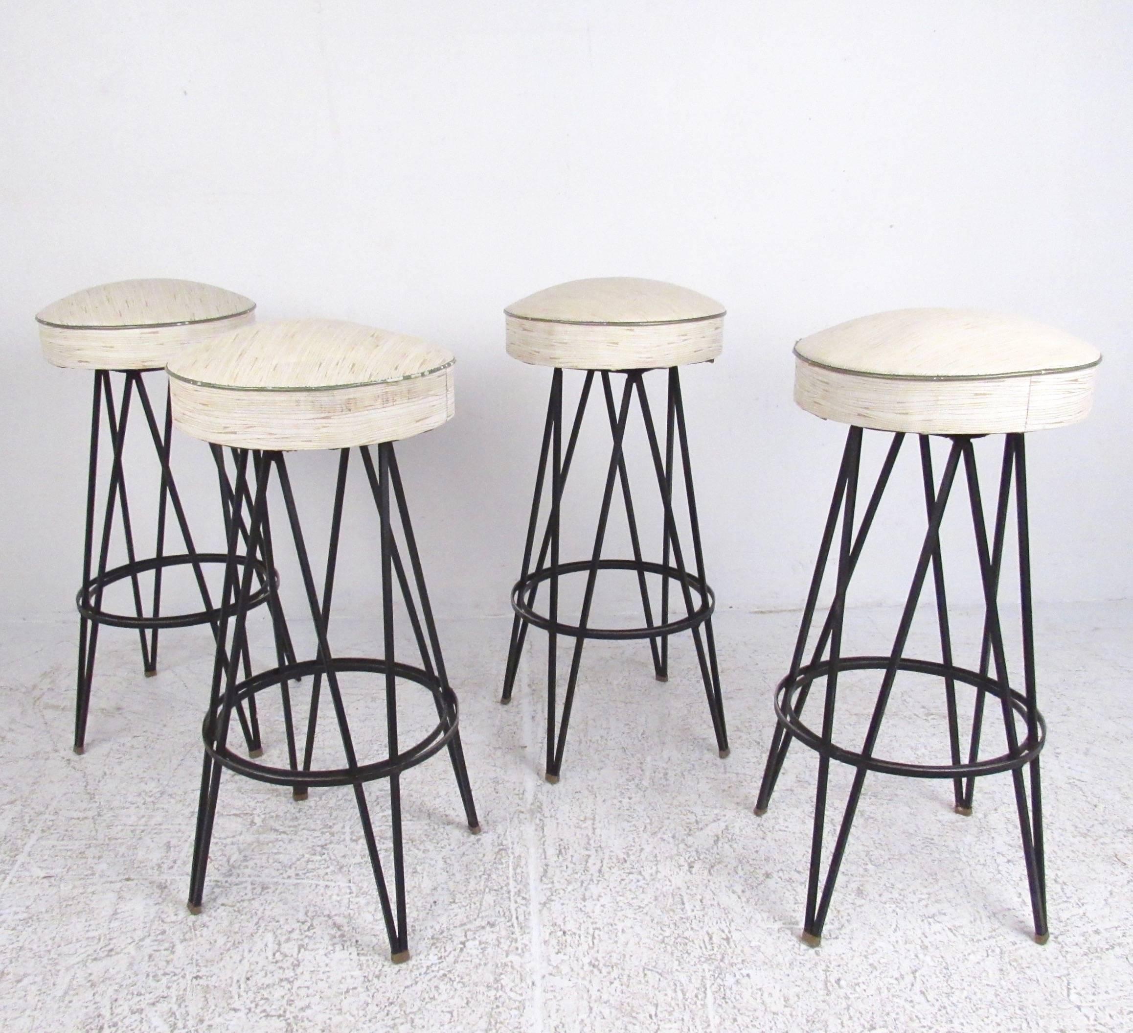This unique set of four vintage bar stools feature timeless mid-century modern design, vinyl swivel seats, and sturdy iron hairpin legs. At a 31 inch seat height this set of bar height stools includes the original vintage finish, distinctive style,