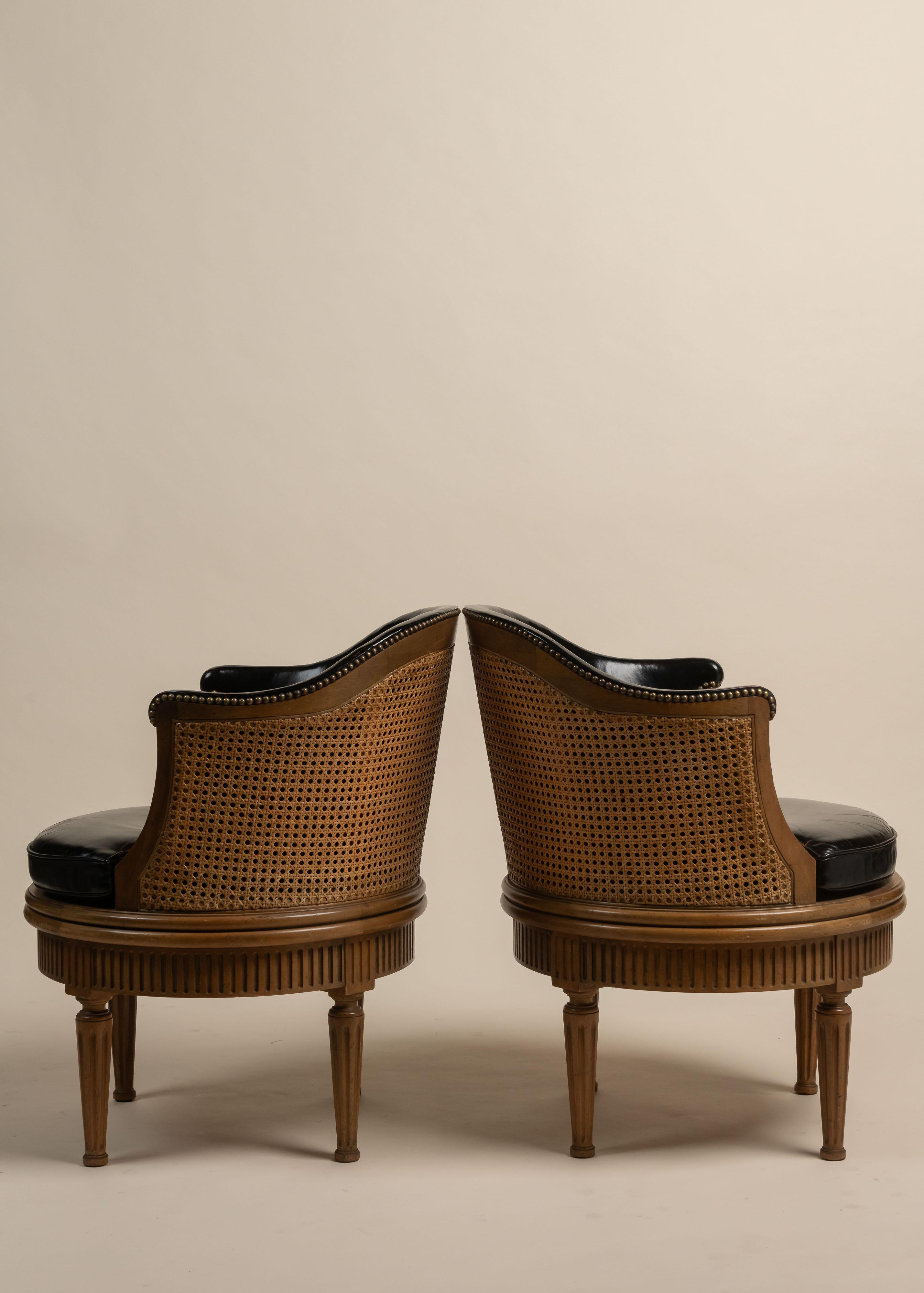 Un raro set di cinque poltrone girevoli vintage di Baker Furniture, realizzate negli anni '60. Queste sedie di produzione americana presentano una solida struttura in mogano con una finitura calda e invecchiata che mette in risalto le venature