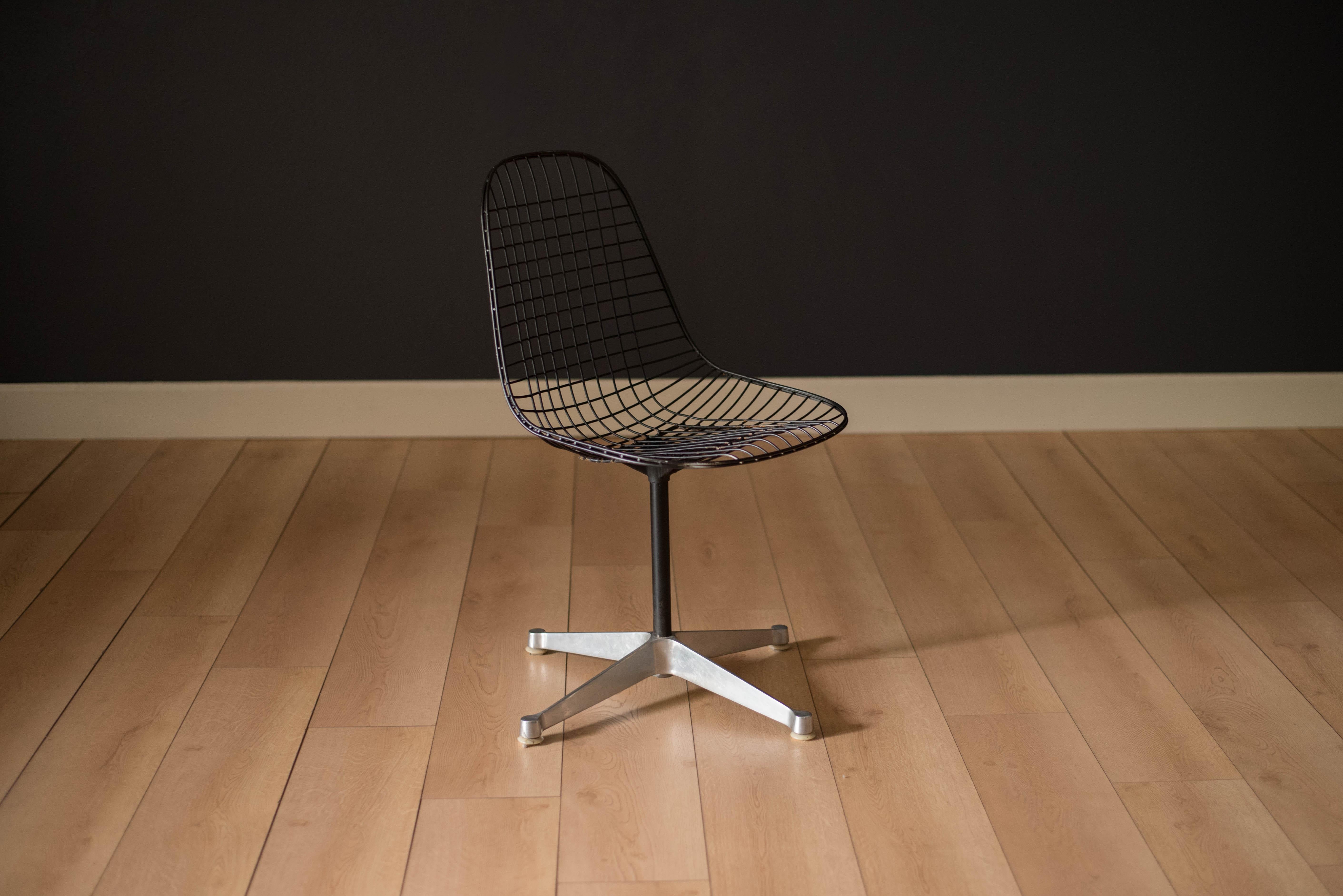 Mid century original PKC wire chair designed by Ray and Charles Eames for Herman Miller, circa 1950s. This piece is made of molded black steel wire and an aluminum cast X-base on glides. Swivel seat fully functions and can be used as an office desk