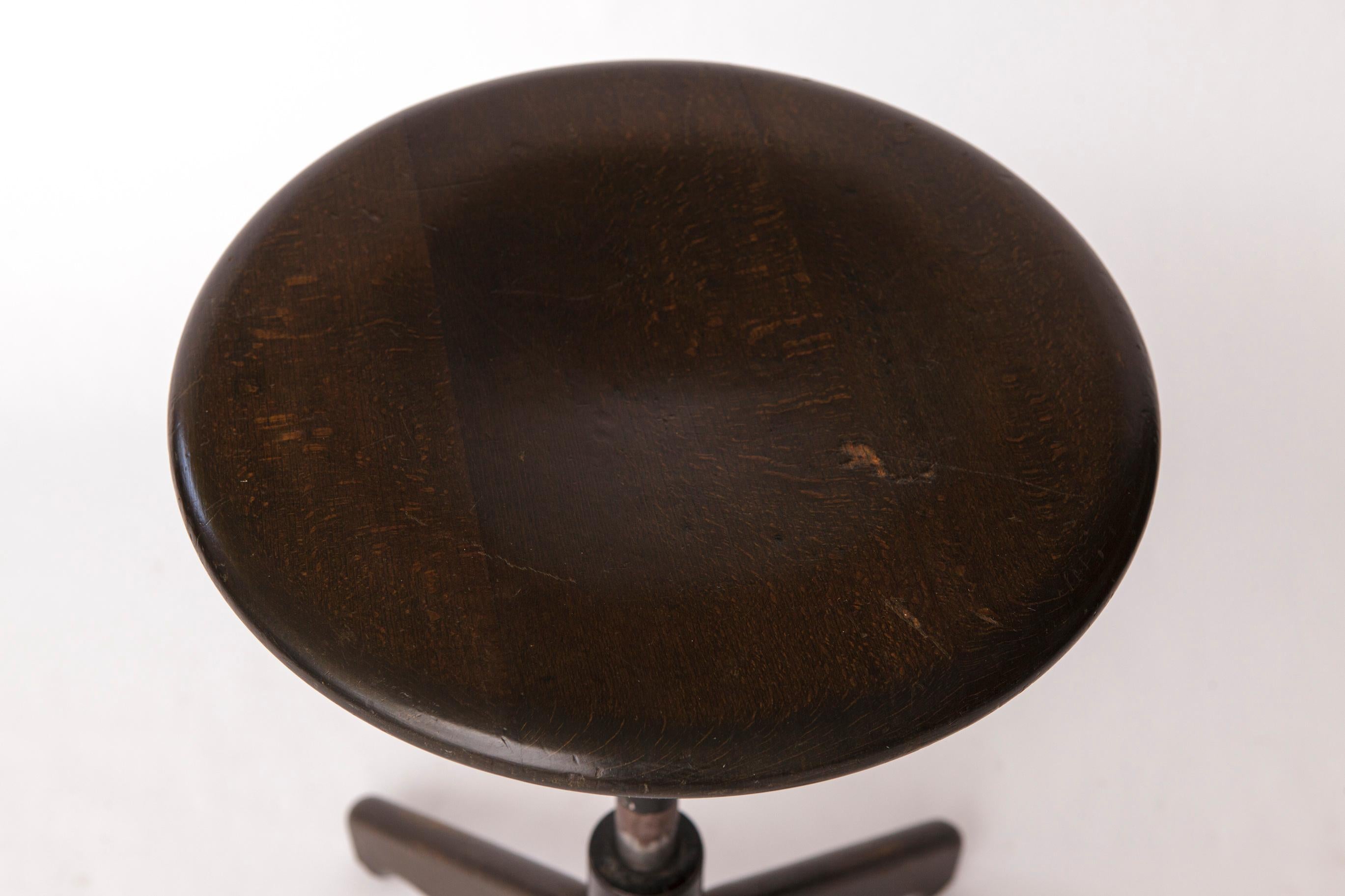 Sgabello girevole vintage degli anni '50-'60 - origine tedesca
Produttore sconosciuto.

Realizzato in legno di Beeche o Oak, con finitura scura.
Nel complesso è in buone condizioni, con un meccanismo a molla che risponde delicatamente quando ti