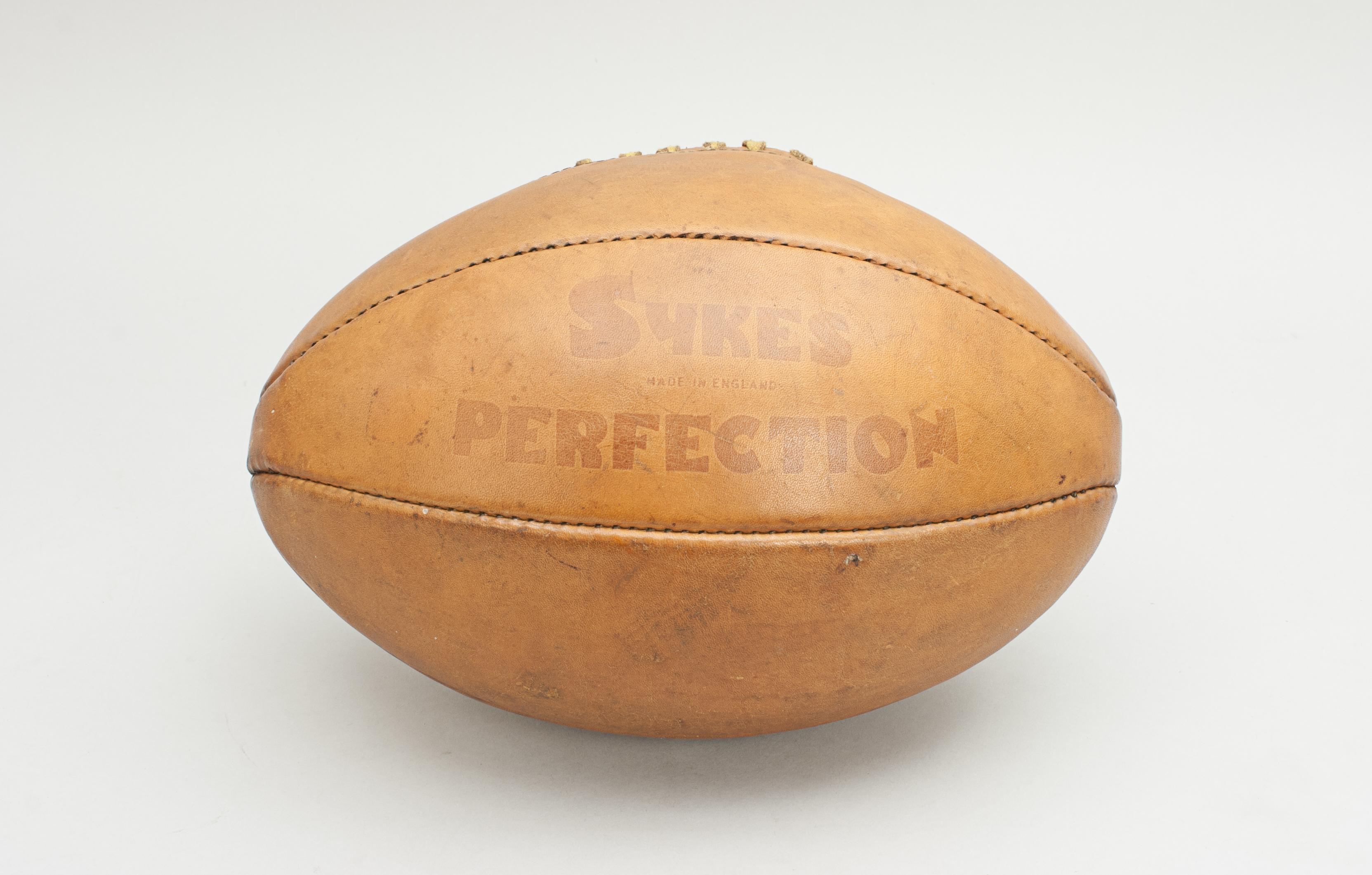 Sykes, perfection rugby ball.
A great looking traditional leather rugby made by Sykes. The ball with a lace-up slit to the top and made from six leather panels. A great ball, with excellent colour, stencilled, 'Sykes, made in England,