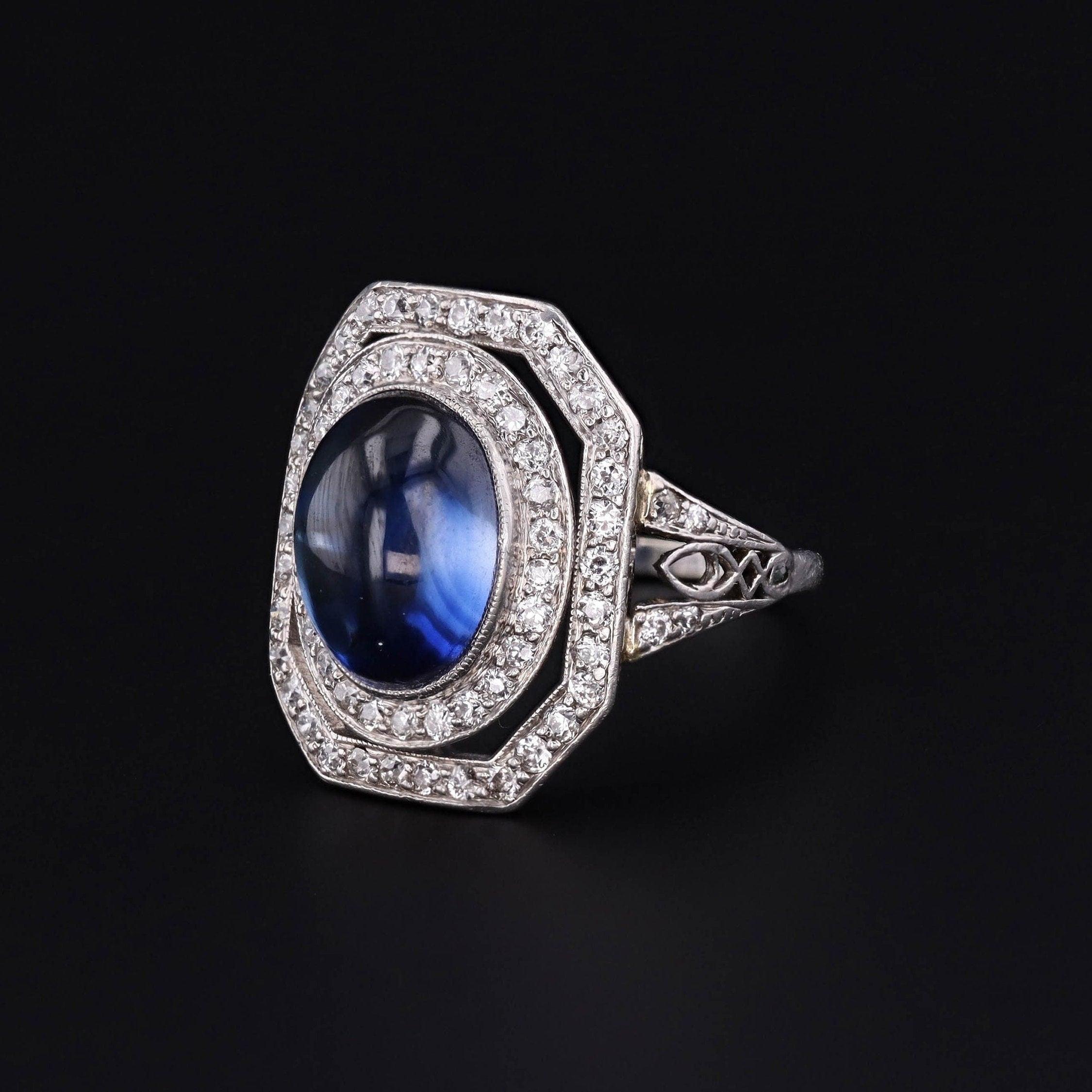 Sapphires are often associated with royalty and are thought to attract blessings and gifts.

This vintage platinum ring (circa 1920-1930) features a deep blue synthetic sapphire cabochon, framed by glittering diamonds.

The face of the ring measures