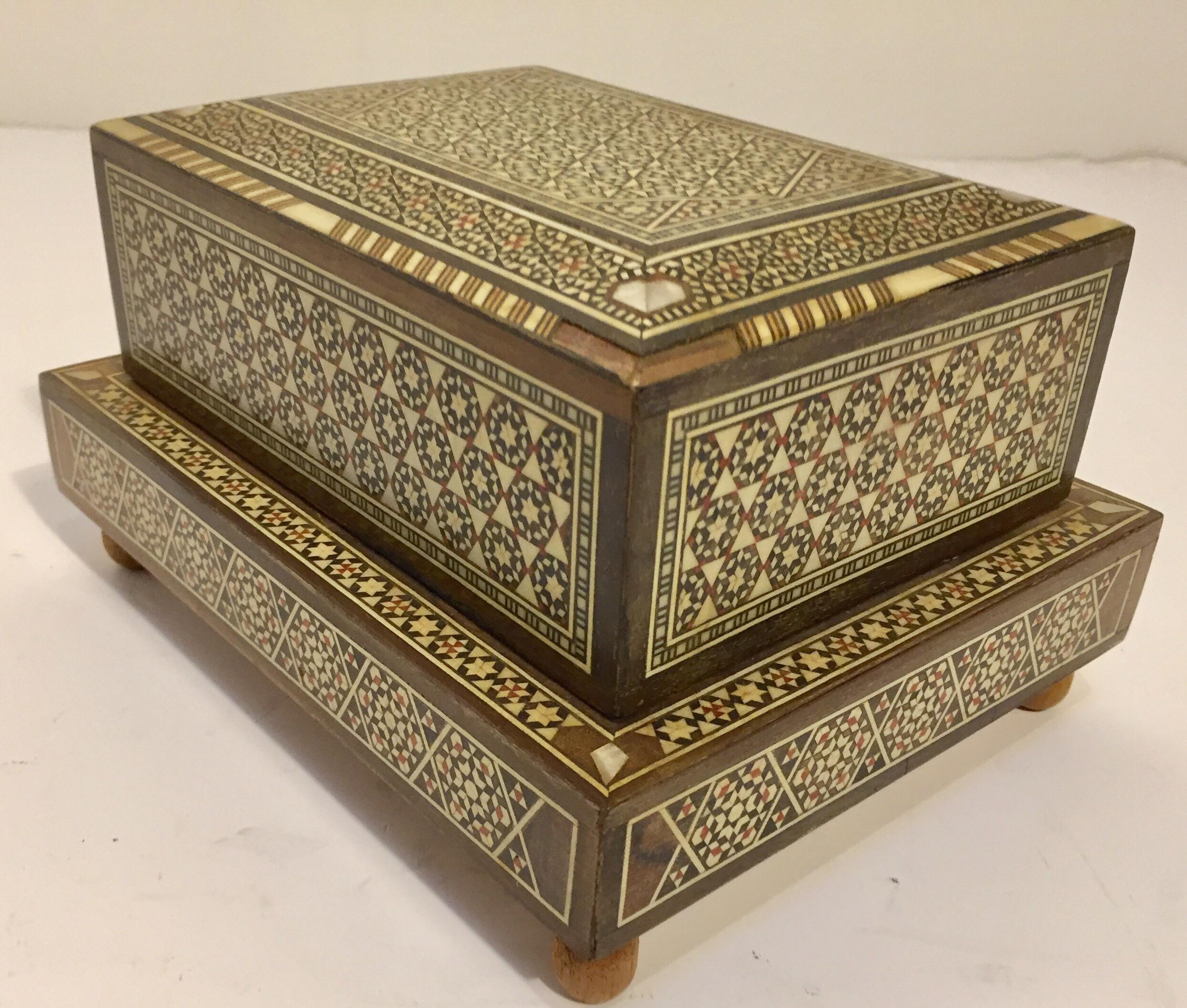Vintage Syrian cigarette music box inlaid with mother of pearl, ivory and ebony.
Handcrafted very fine Moorish Sadeli micro mosaic inlaid geometric marquetry artwork.
These Middle Eastern boxes are used to store cigarettes and play music when you