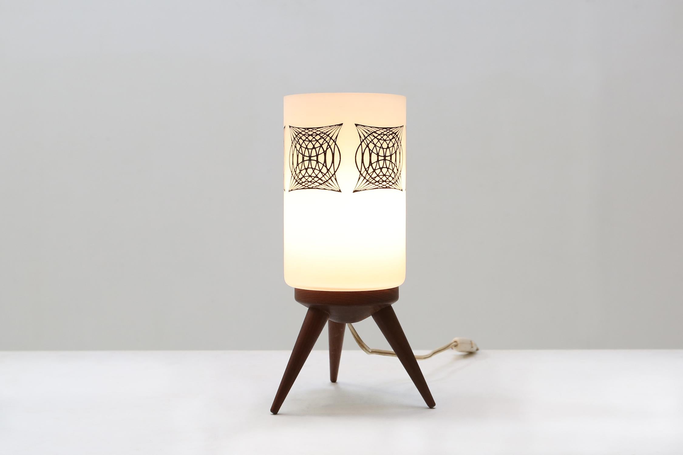 French vintage table lamp made of opaline glass and a teak wooden base.
Has a nice sculpture on the side of the glass.