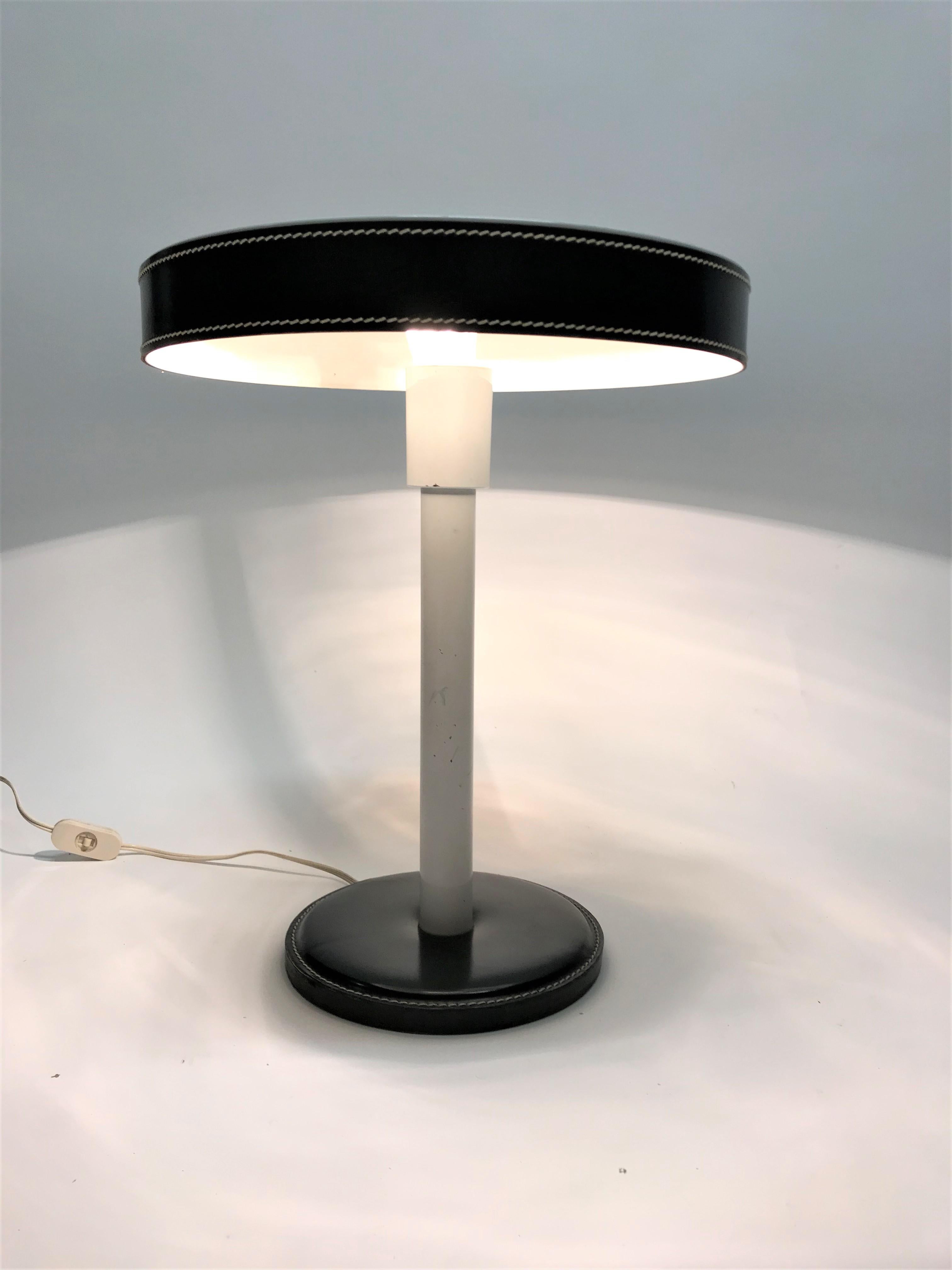 Mid-Century Modern desk lamp made from metal and covered with leather, designed by Frenchman Jacques Adnet (1901-1984). Jacques Adnet was a representative of French modernism.

The lamp is in very good condition with some minor marks on the