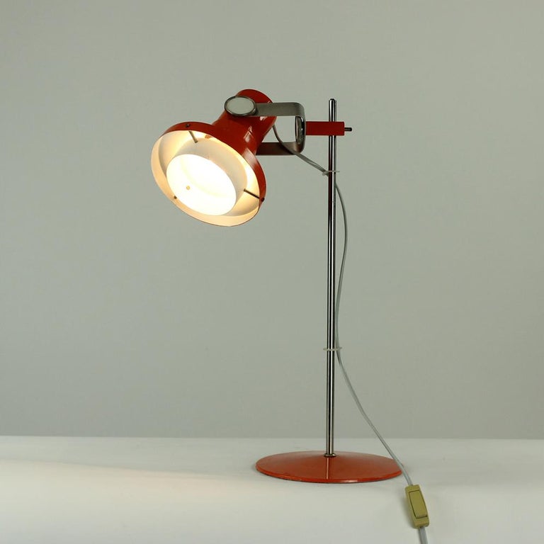 Midcentury table lamp in beautiful design, so very typical for the era. Produced in Czechoslovakia in 1960s by Kamenicky Senov. Designed by Pavel Grus. The bright combination of orange metal, white and steel, makes this item timeless. Really nice