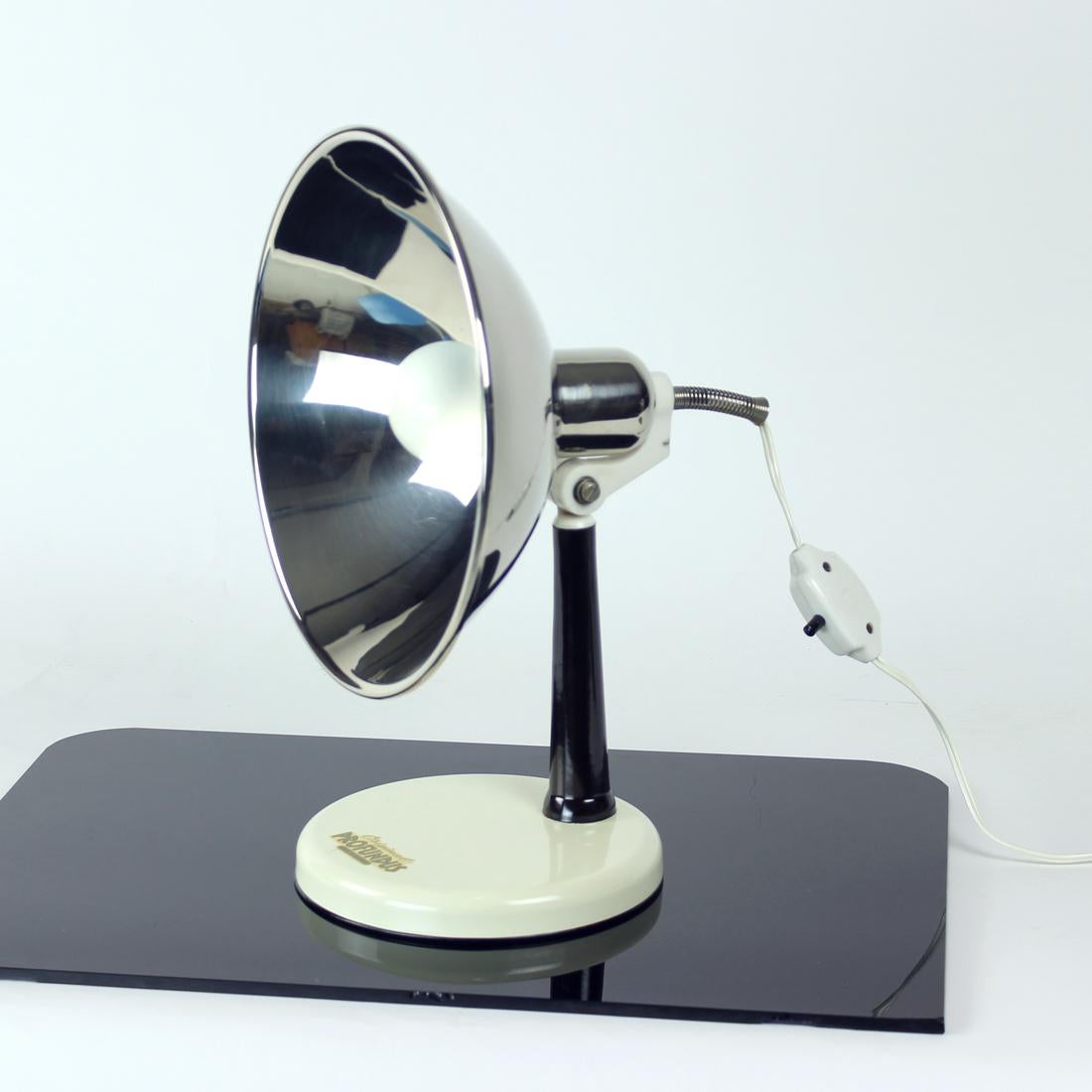 Belle lampe de bureau produite en Autriche dans les années 1950. À l'origine, la lampe était utilisée comme lampe thermique, d'où le bouclier en métal chromé. Il est en excellent état et la marque d'origine est toujours présente. La base est de