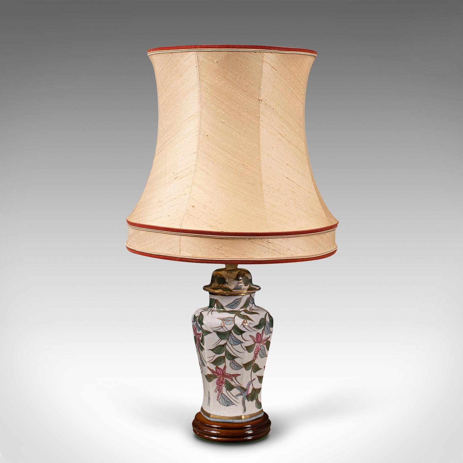 This is a vintage table lamp. A Chinese, ceramic decorative light, dating to the late Art Deco period, circa 1940.

Of pleasing foliate decoration, with a distinctive quality shade.
Displays a desirable aged patina and in good order.
Hexagonal