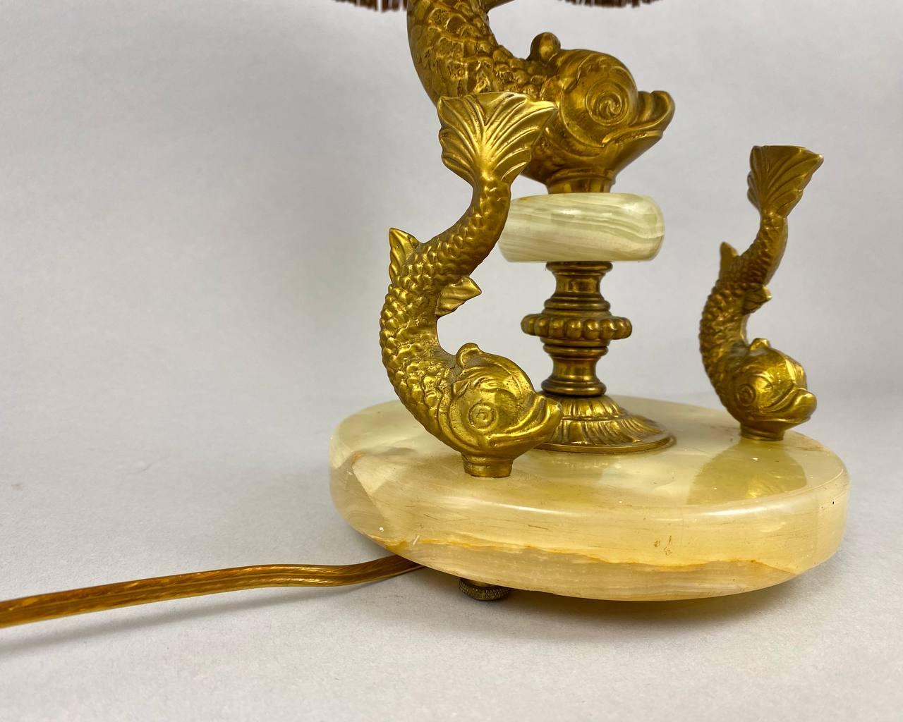 Very beautiful table lamp with elements of natural onyx stone and bronze will find its place in the living room and in your bedroom.

 The base of the lamp is made of onyx, and the figures of very detailed fish are made of bronze with a decorative