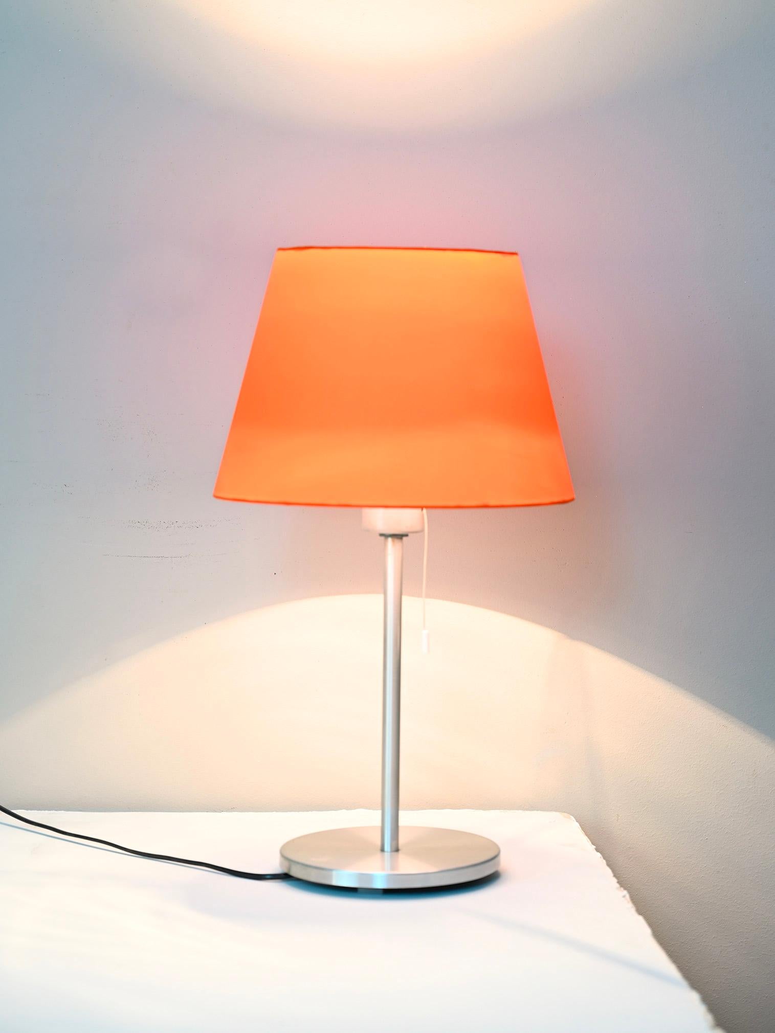 Vintage table lamp of Scandinavian manufacture from the 1970s.

The base is metallic while the lampshade is orange in color and has been remade.

Good condition, lamp works perfectly.

BD066