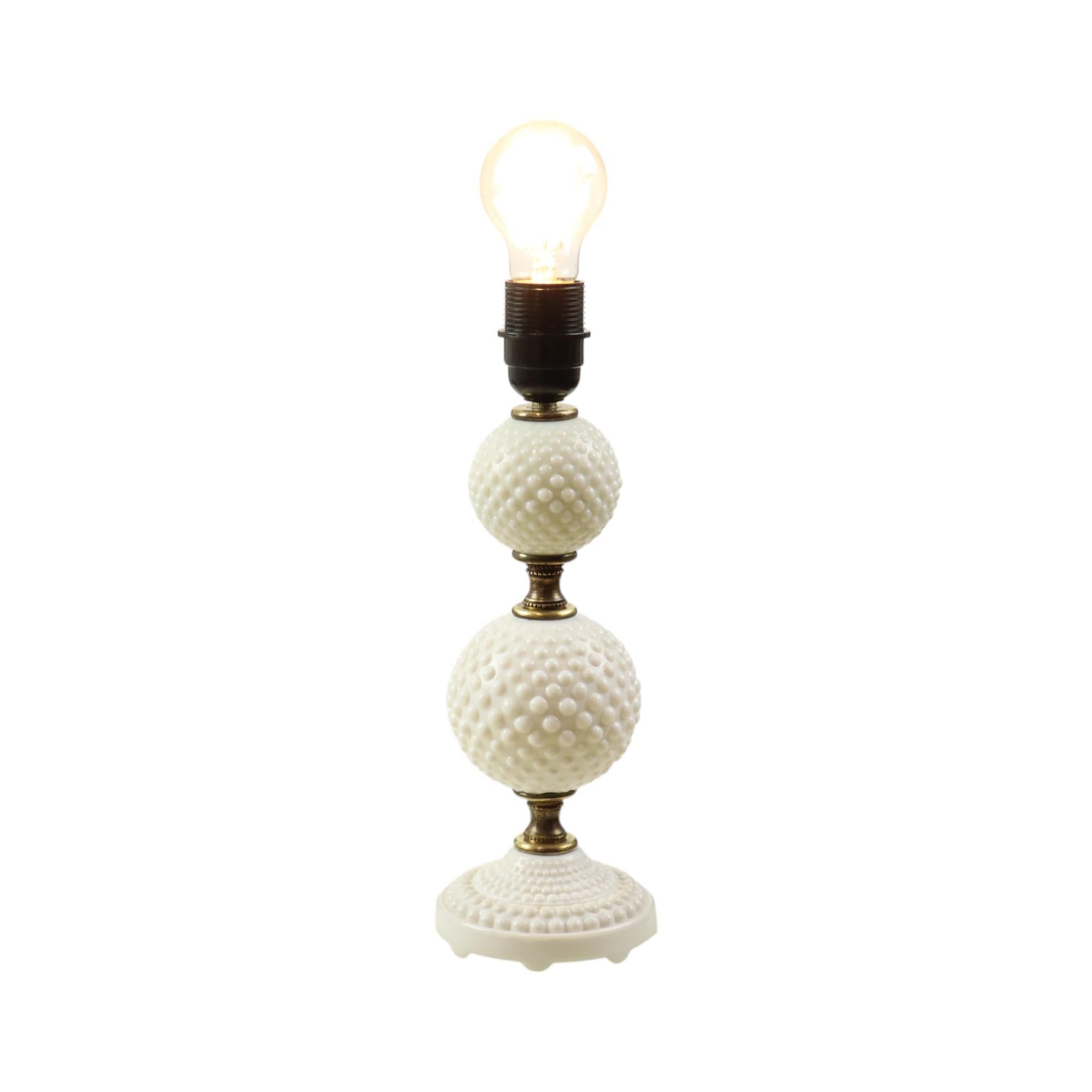 Vintage table lamp made of a round base of milk glass, 2 milk glass balls decorated with hobnails and solid brass intermediate pieces, probably Italian, 70s.

Very nice vintage lamp, very decorative balls with different sized hobnails, or balls,