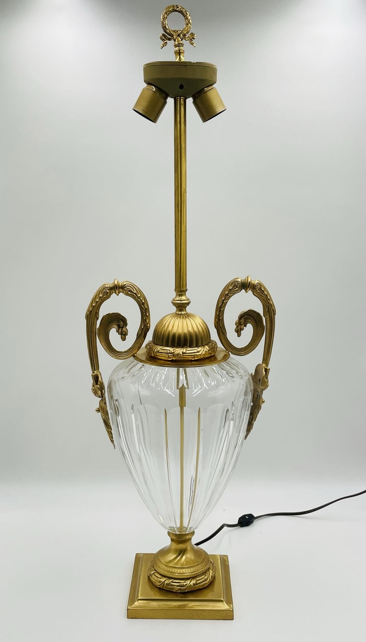 Voici l'étonnante lampe de table des années 1970 en cristal et en bronze, fabriquée en Italie par Leone Alio. Cette lampe exquise arbore un design unique et complexe, avec deux poignées élégantes et une base étonnante qui respire la sophistication