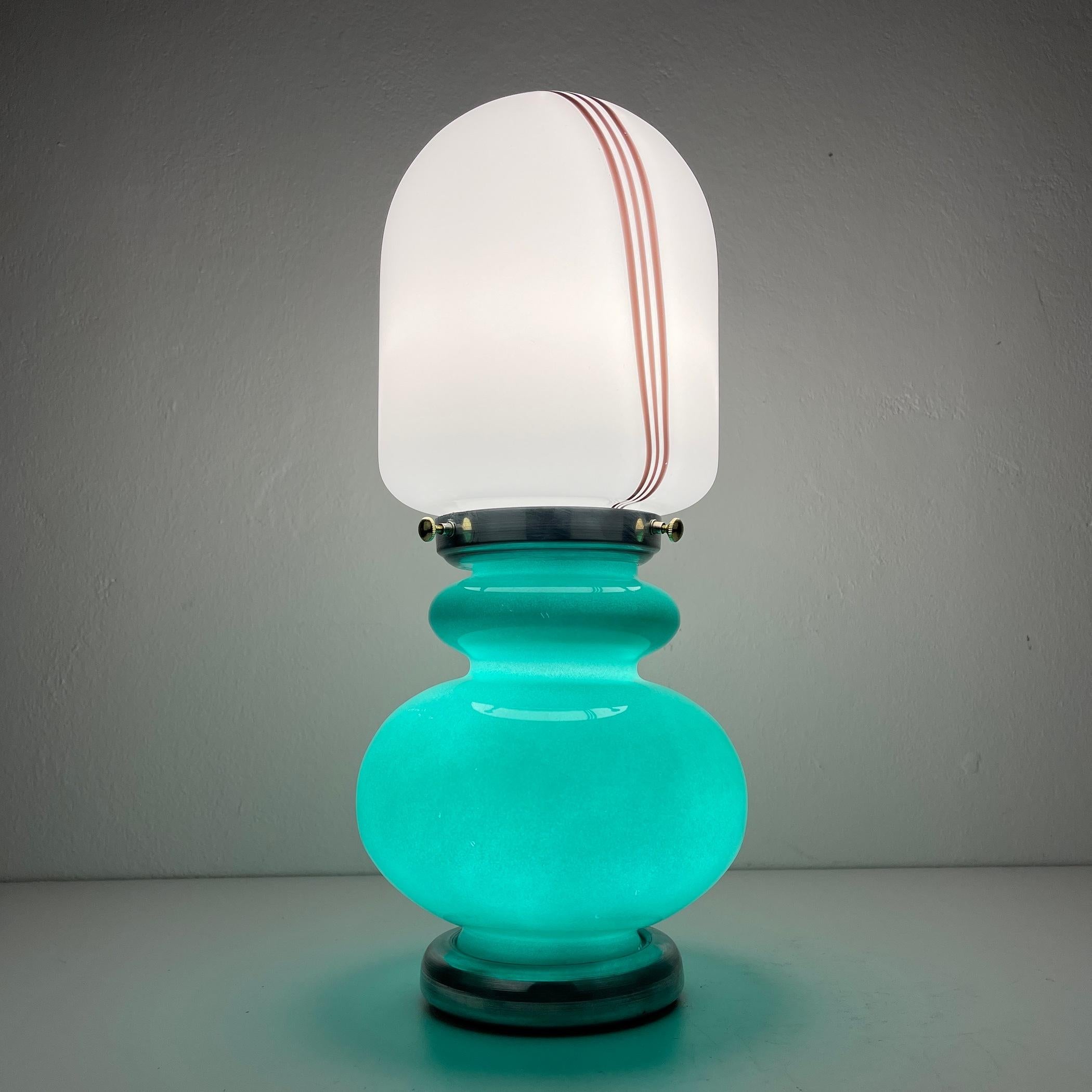 Introducing a charming table lamp, expertly crafted in Italy during the vibrant 1980s. Despite their vintage, this lamp is in impeccable condition, boasting glass that's free from any chips or cracks. This distinctive lamp consist of two glass