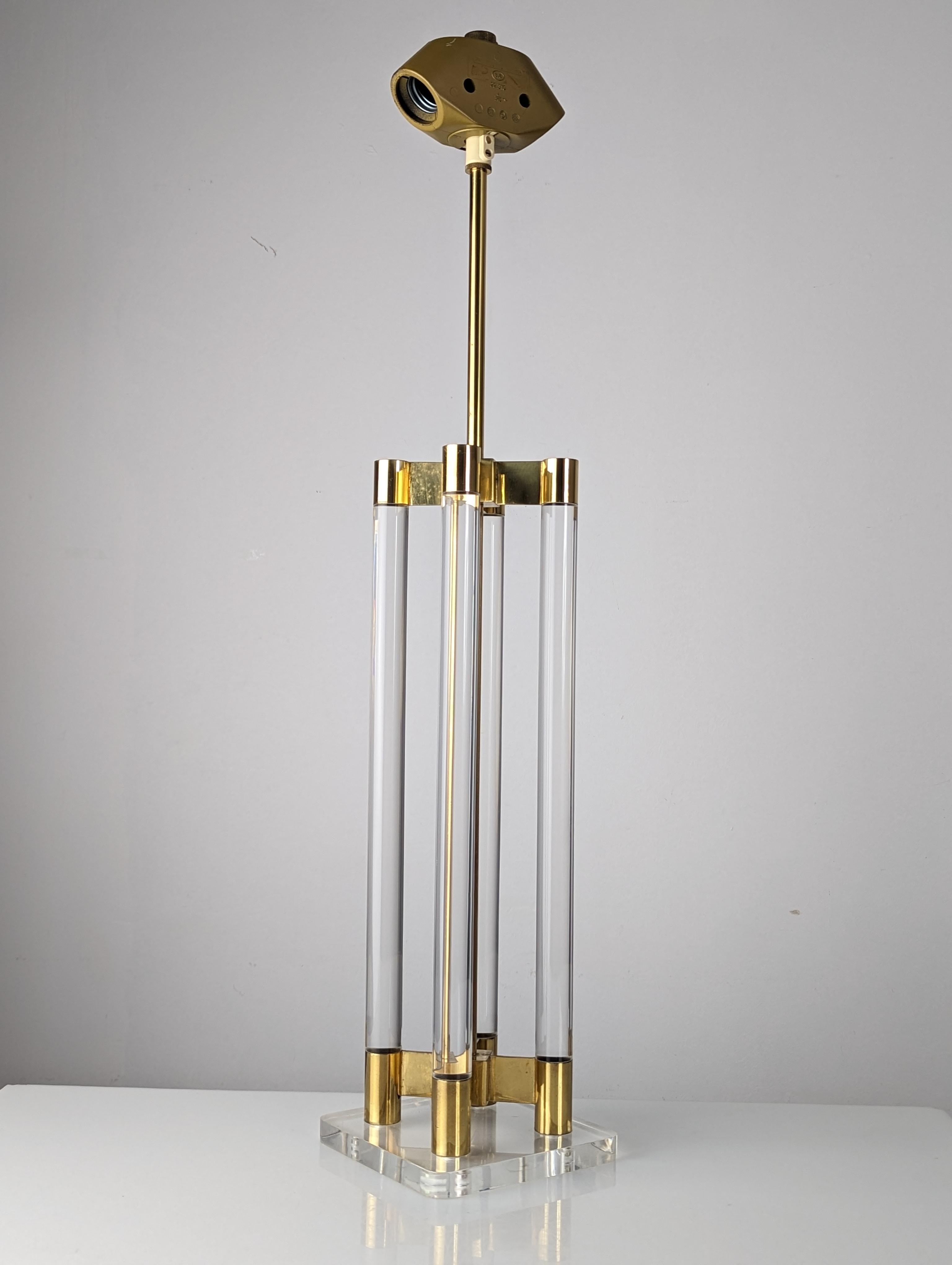 Elegant lamp made of transparent lucite and a central brass structure, in the upper part double cap and upper screw to place a screen that fits with the decoration of the room. This fantastic lamp generates a great sensation of spaciousness that,