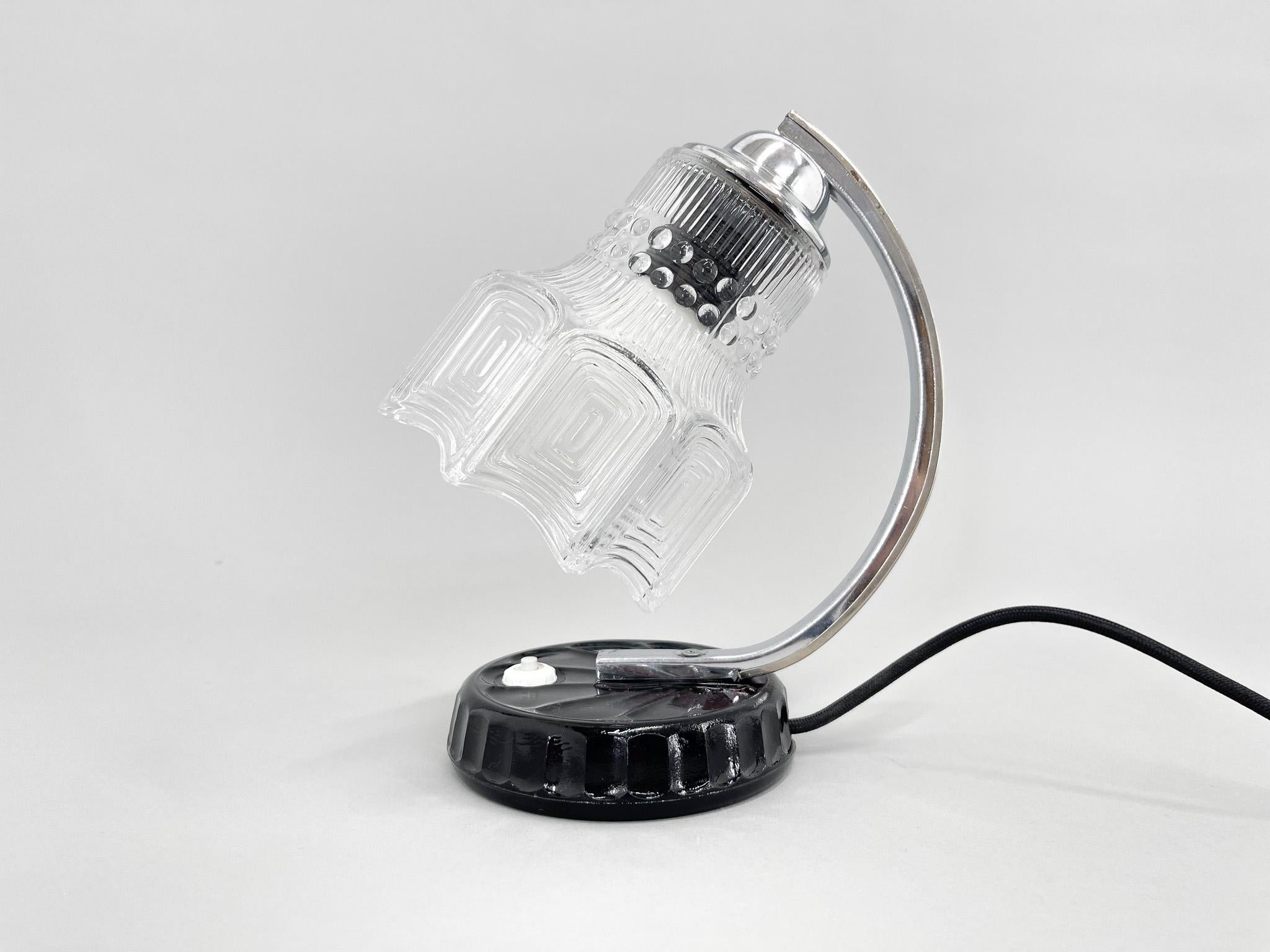 Mid-century table lamp made of chrome, metal, clear glass and black ceramic base. New wiring.