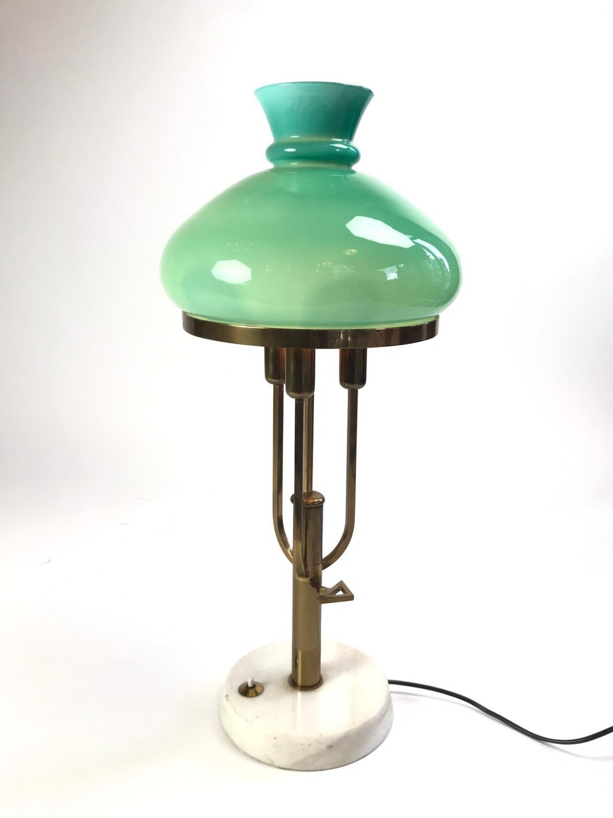 A lovely Italian vintage table lamp comprising of 3 lamps housed in a green hand blown Murano glass shade with a brass stand and marble base. The design is attributed to Ignazio Gardella.
