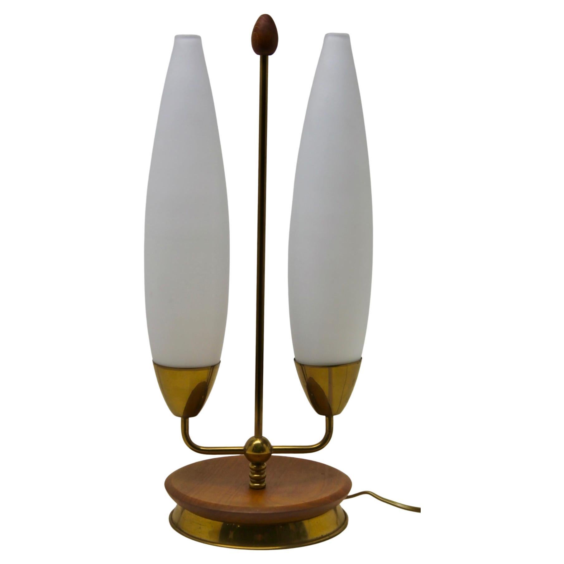 1970s table lamp in the Vintage style with brass fittings on a metal and Wood base. The lamp has a shade made of acid-etched milk-glass giving it a matte, white surface, and provides a strong up-light with a softer, diffused light at eye