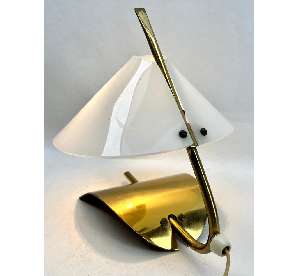 Lampe de table des années 1970 dans le style By avec des accessoires en laiton  La lampe est dotée d'un abat-jour en plexiglas qui lui confère une surface blanche et mate. Elle fournit une lumière forte vers le bas et une lumière plus douce et