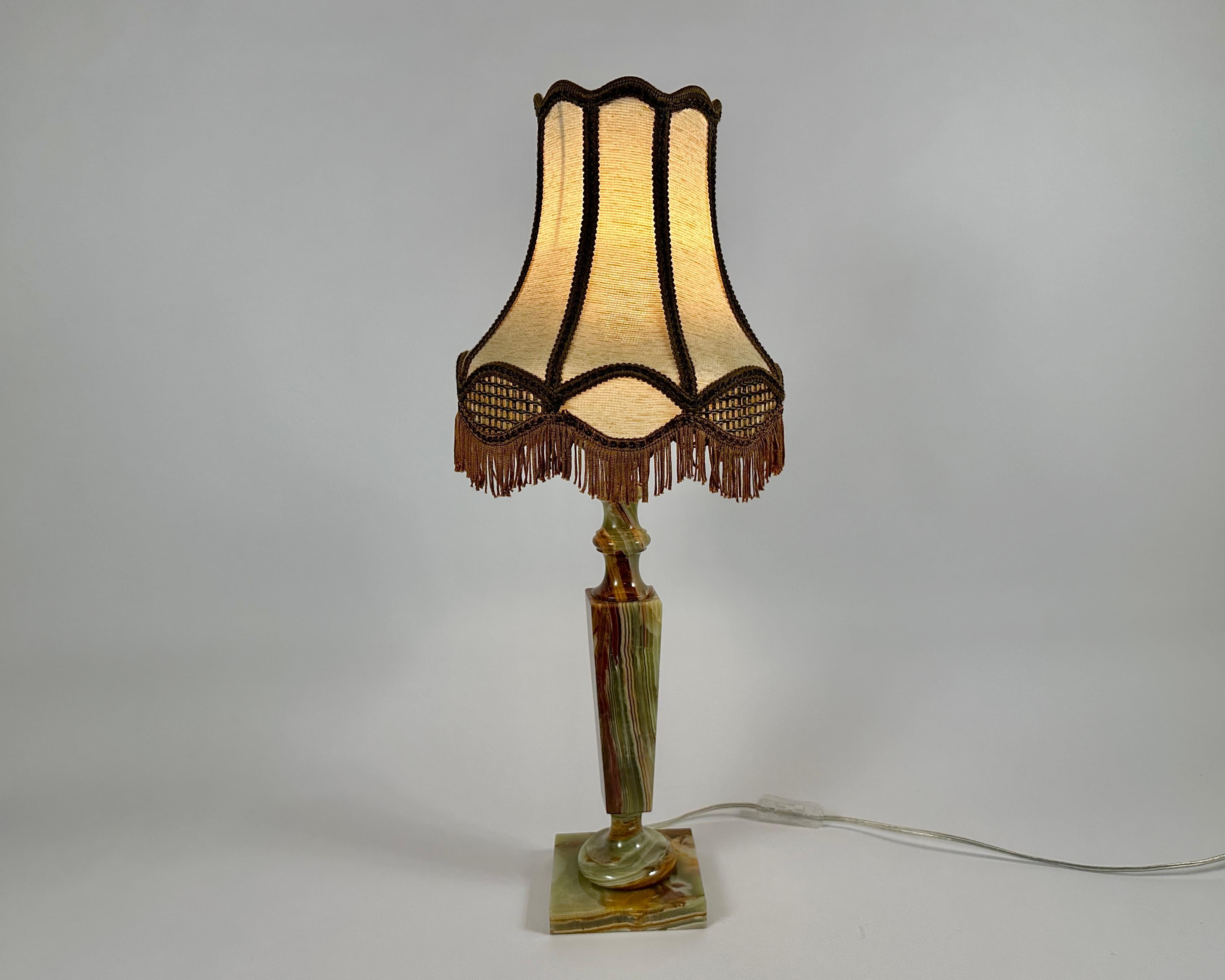Splendida e lussuosa lampada da tavolo in onice con paralume in tessuto beige proveniente dal Belgio, anni '70.

La lampada è decorata con un paralume a forma di cono con una frangia. È realizzata in tessuto marrone beige. Il tessuto è denso e