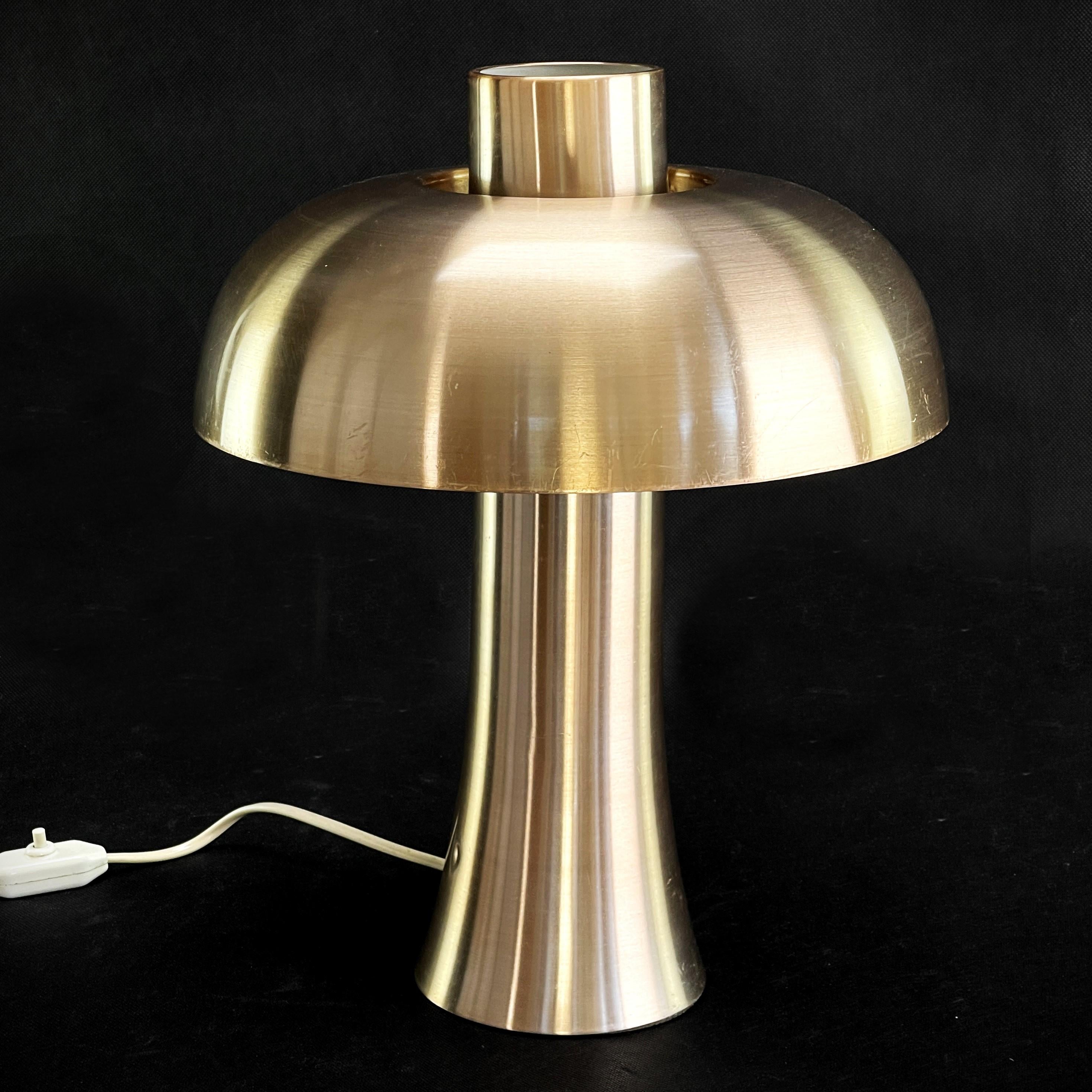 Lampe à poser Doria en aluminium - années 1970

La lampe à poser Doria Mushroom des années 1970 est un véritable classique du design rétro. Cette lampe de table séduit par sa surface anodisée de couleur cuivre en aluminium brossé, qui lui confère un