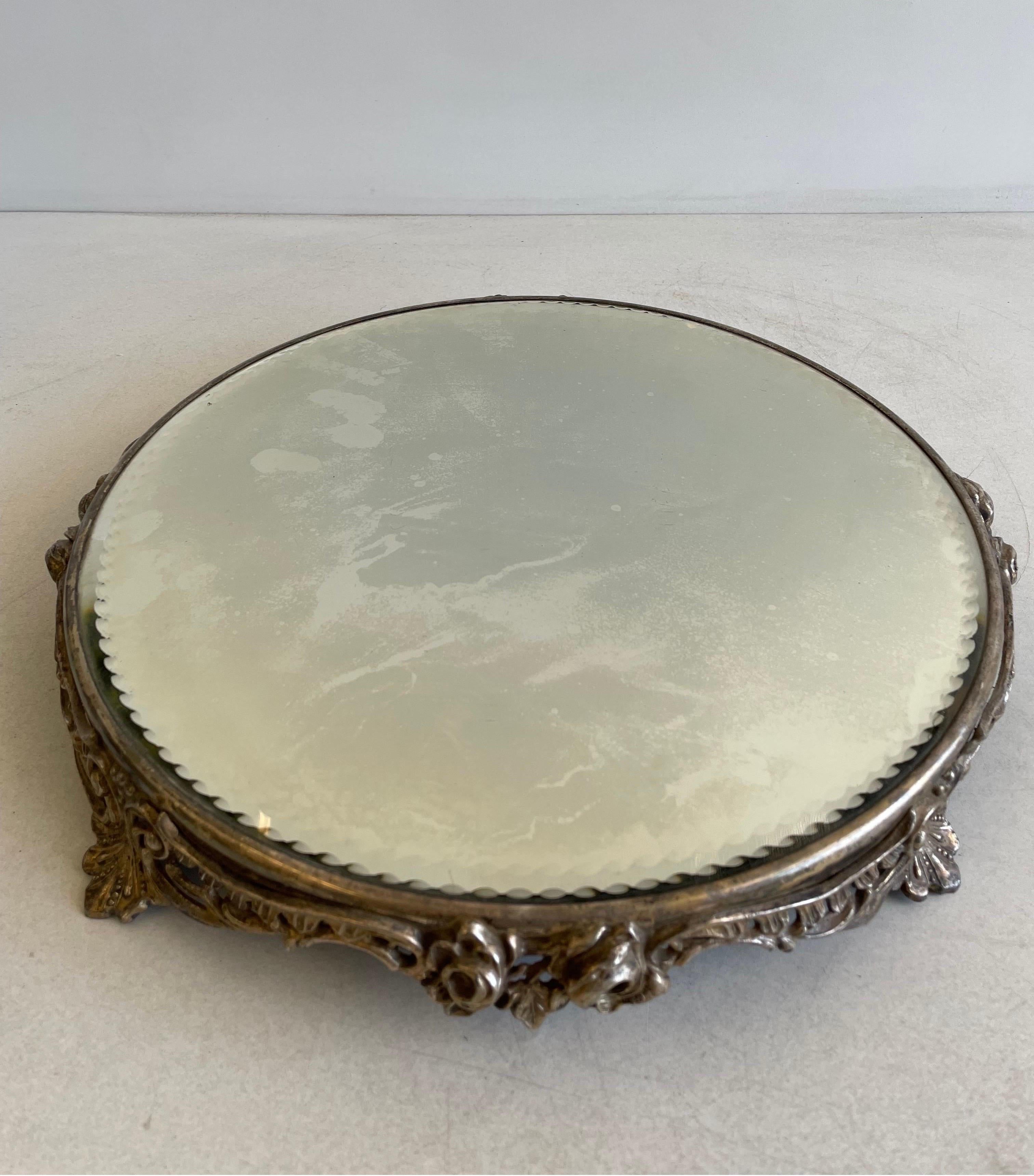 Antique plateau beveled glass mirror with a very ornate metal base! The mirror with some minor silver loss.. Not showing up in the picture are many short, light surface scratches. No chips, cracks or flakes on the nicely beveled mirror. The metal