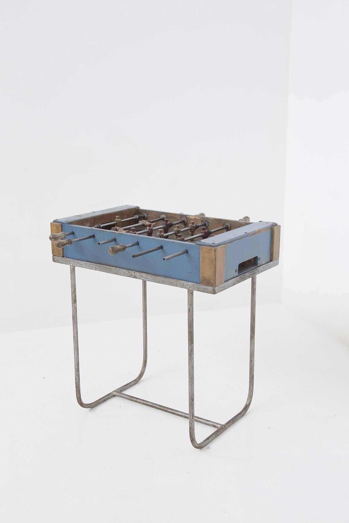 This charming foosball table, with its worn and authentic look, exudes an unmistakable vintage appeal that takes us back to a time when playing was a simple and genuine moment of sharing. The visible wear on the wood and metal details tells stories