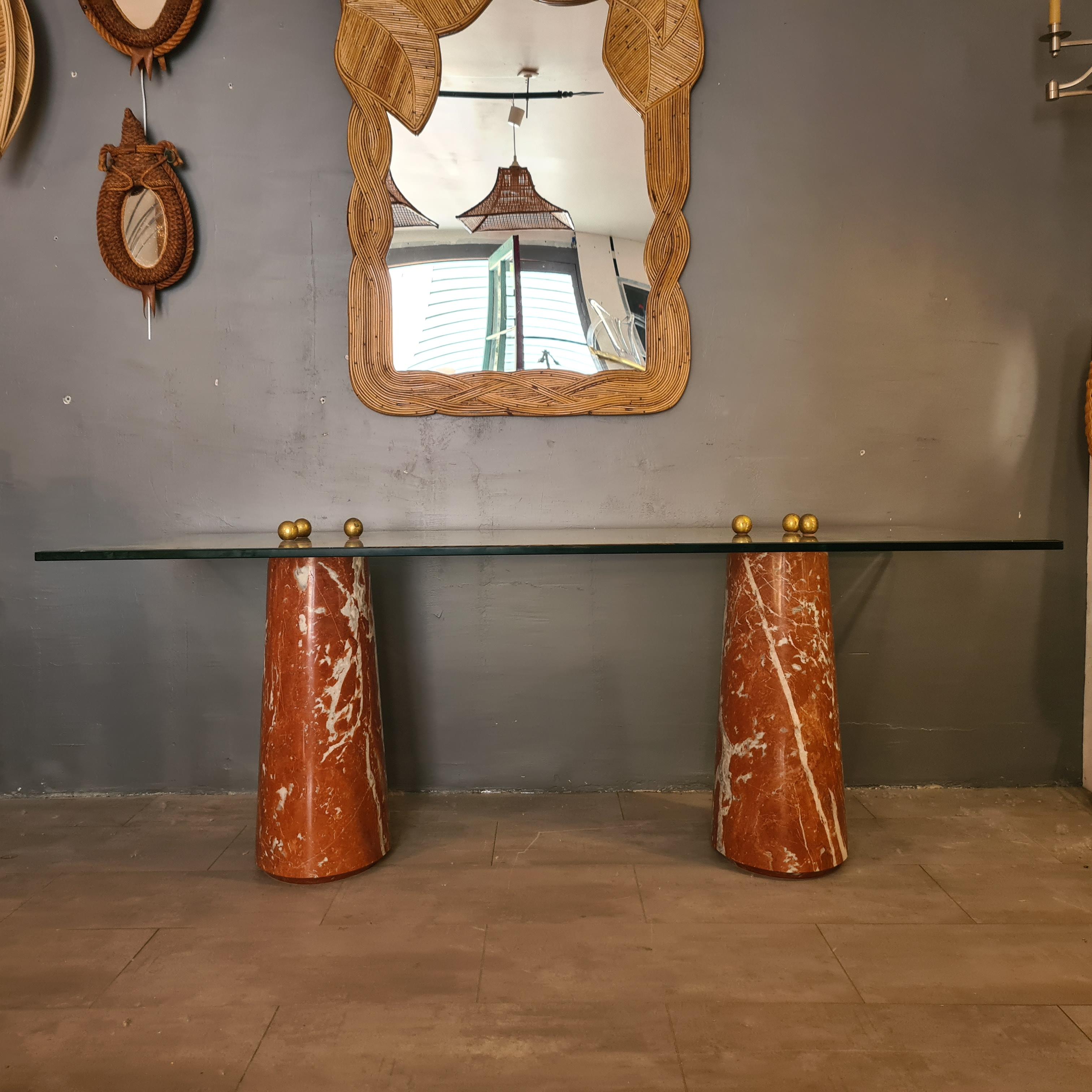 Vintage table with legs in the red Languedoc marble, thick glass top and balls that screw in gilded bronze.