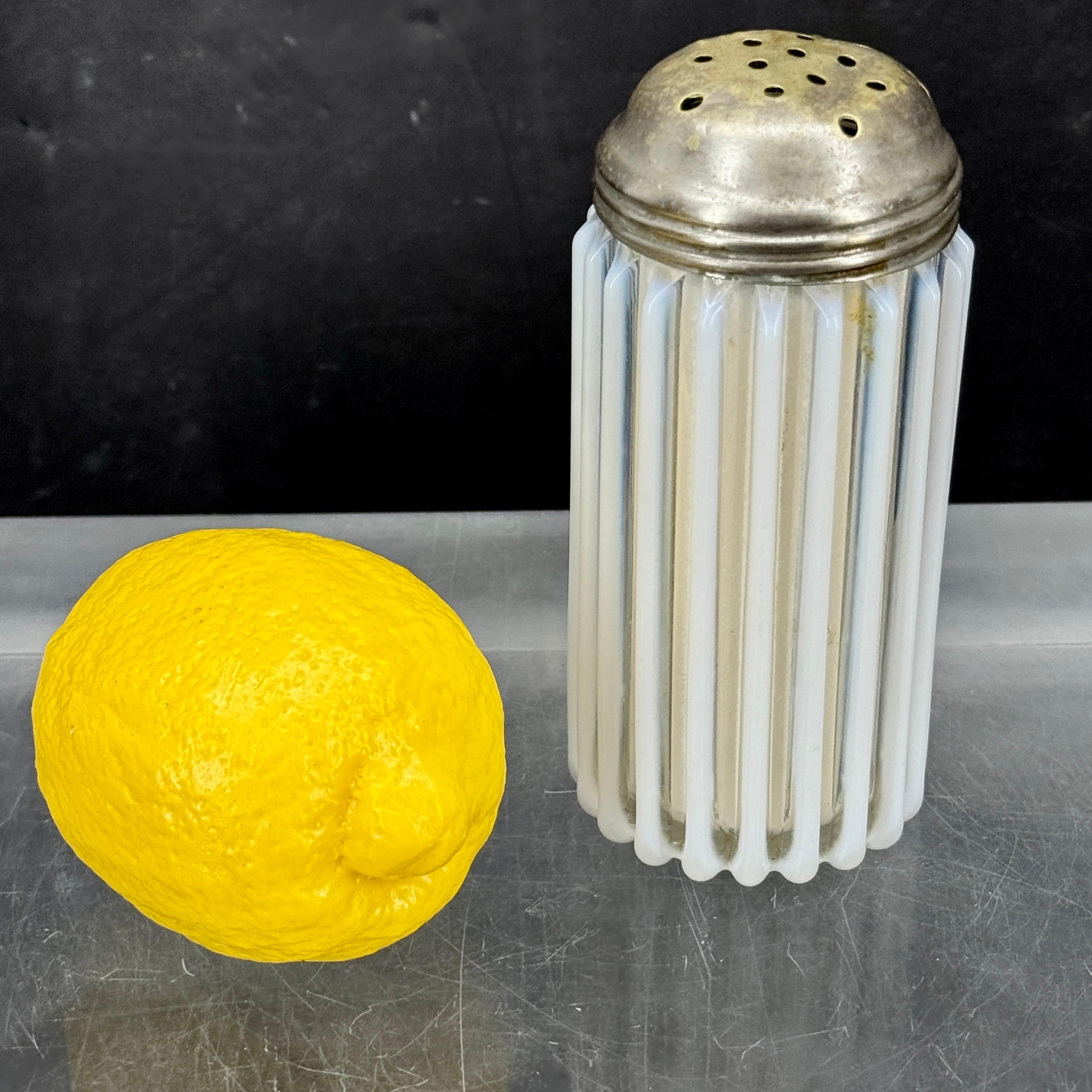 Opalglasstreuer im Vintage-Stil, der üblicherweise zum Streuen von Gewürzen wie Parmesan, Zucker, Zimt, Salz oder Pfeffer verwendet wird. Das gerippte Gefäß hat eine unschlagbare Patina und weist mehrere Perforationen im Metalldeckel auf. Er ist zum