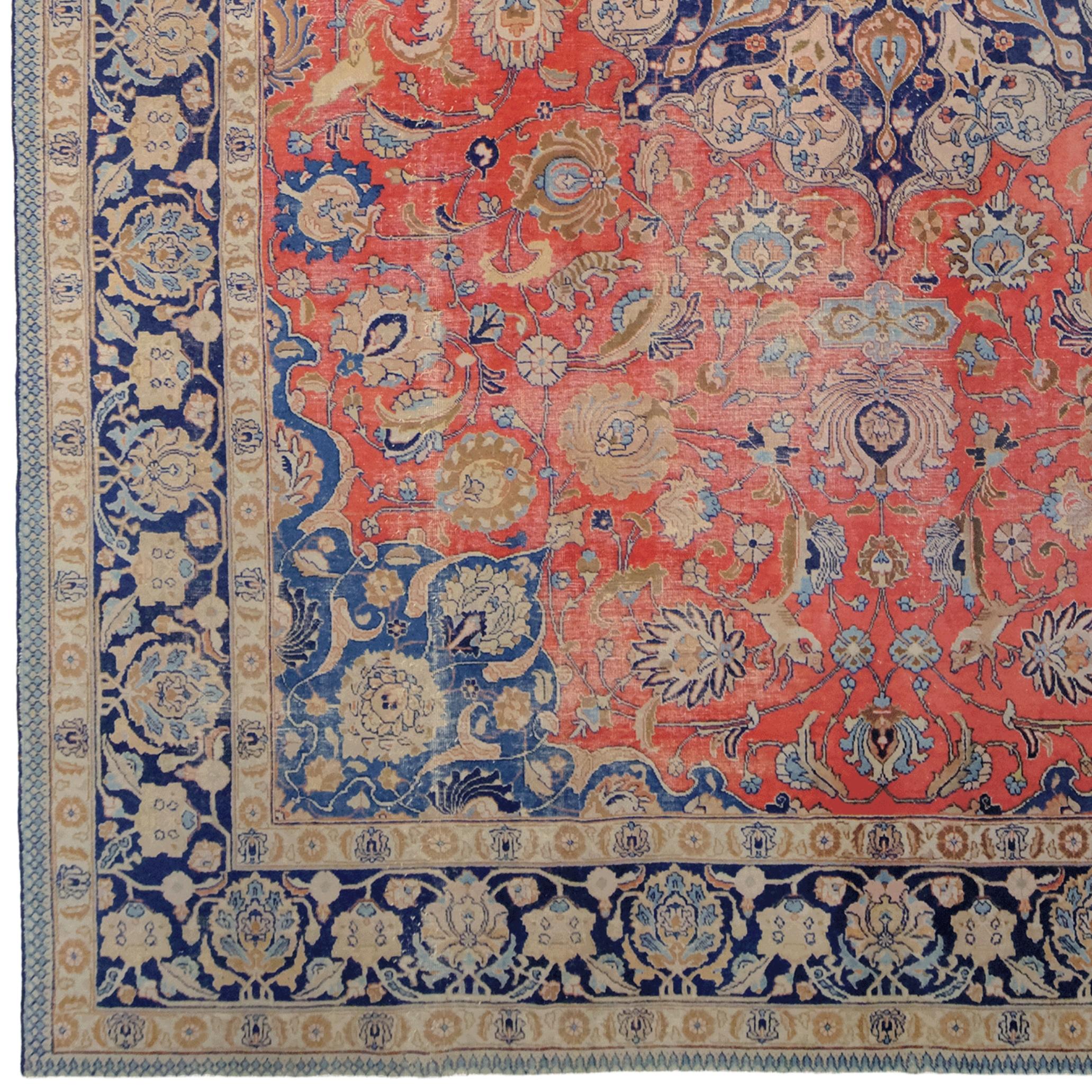 Here is a rare Tabriz carpet from the early 20th century. This magnificent carpet was hand-woven in Tabriz, Iran, and has continued to reflect the grandeur of the past for centuries.

Eye-catching with its striking red, blue, and gold hues, this