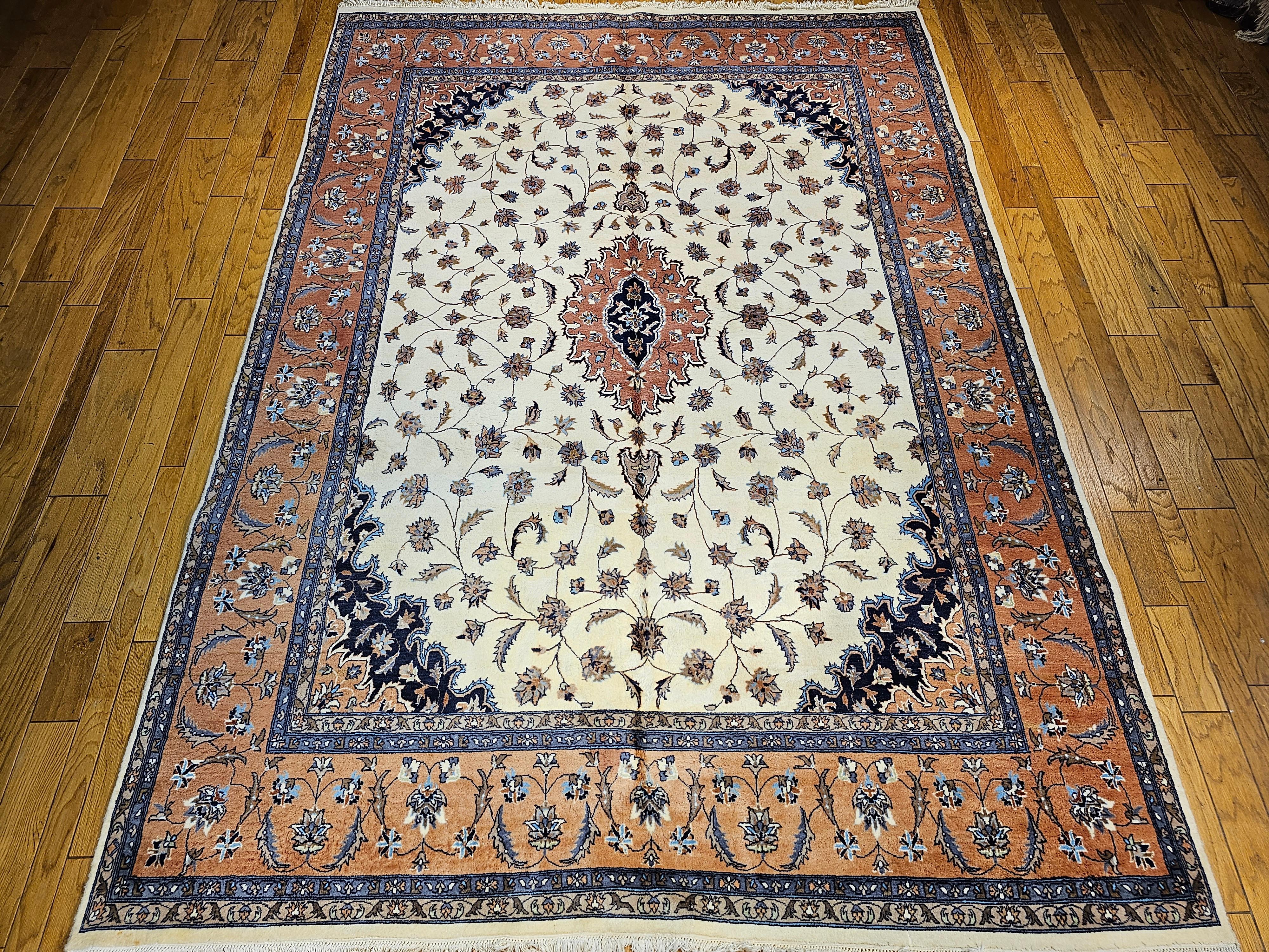 Vintage handgeknüpft Tabriz Design Teppich in Zimmergröße in einem floralen Muster in Elfenbein, Terrakotta rot, marineblau und braun aus dem 4. Quartal der 1900er Jahre. Der Teppich hat ein elfenbeinfarbenes Feld mit einer terrakotta- oder