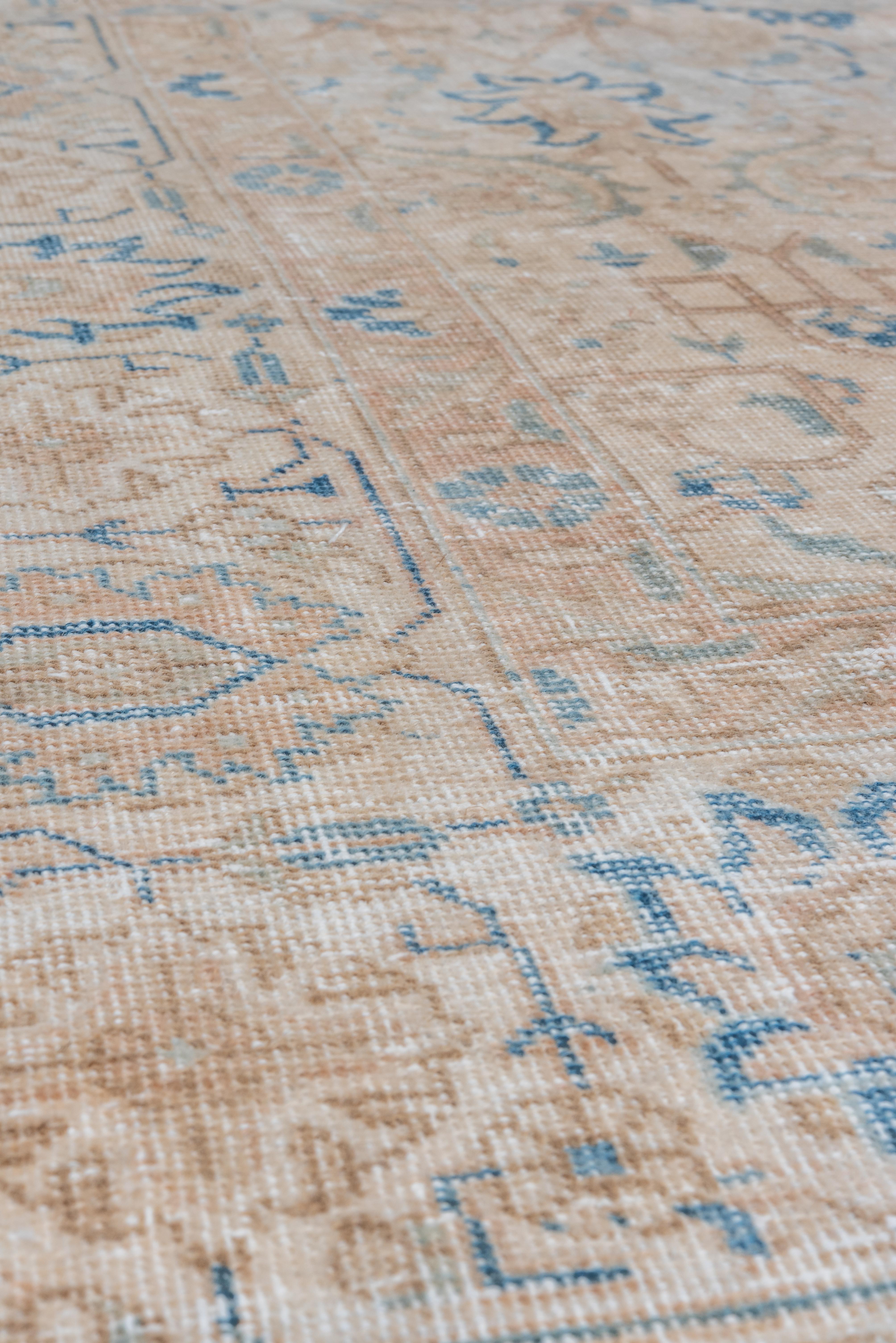 This vintage Tabriz rug is rendered in a time-softened palette of sand, taupe, and pale ivory with delicate azure blue detailing. The floral medallion layout is subtly defined, with scrolling vinework, rosettes, and palmettes woven into a nearly