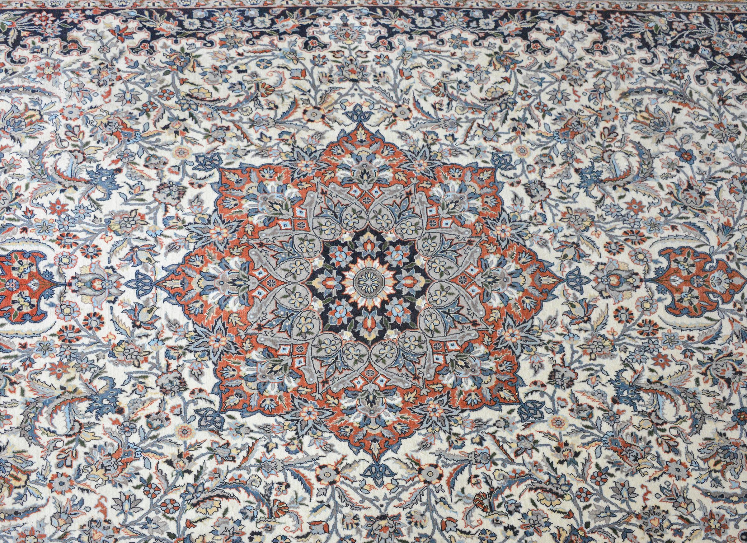 A beautiful and mesmerizing vintage Persian Tabriz rug with a large central floral medallion with amidst a tightly woven field of more scrolling vines and flowers and surrounded by a wide border with more large-scale flowers and vines.