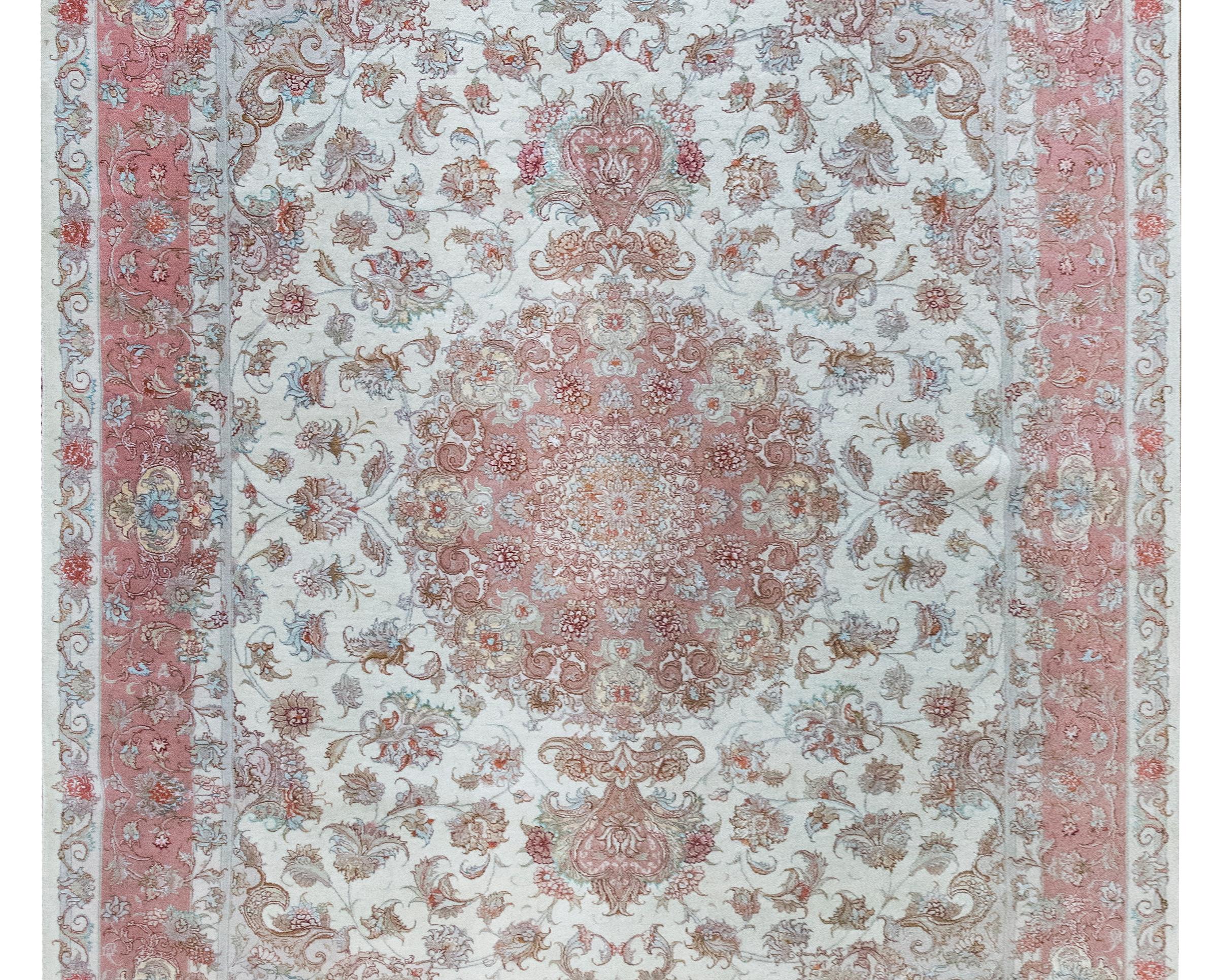 Questo tappeto persiano Tabriz vintage della fine del XX secolo presenta un ipnotico medaglione floreale centrale, intessuto con intricati fiori, foglie arricciate e delicati rampicanti. Il medaglione fiorisce all'interno di un campo di lana bianco