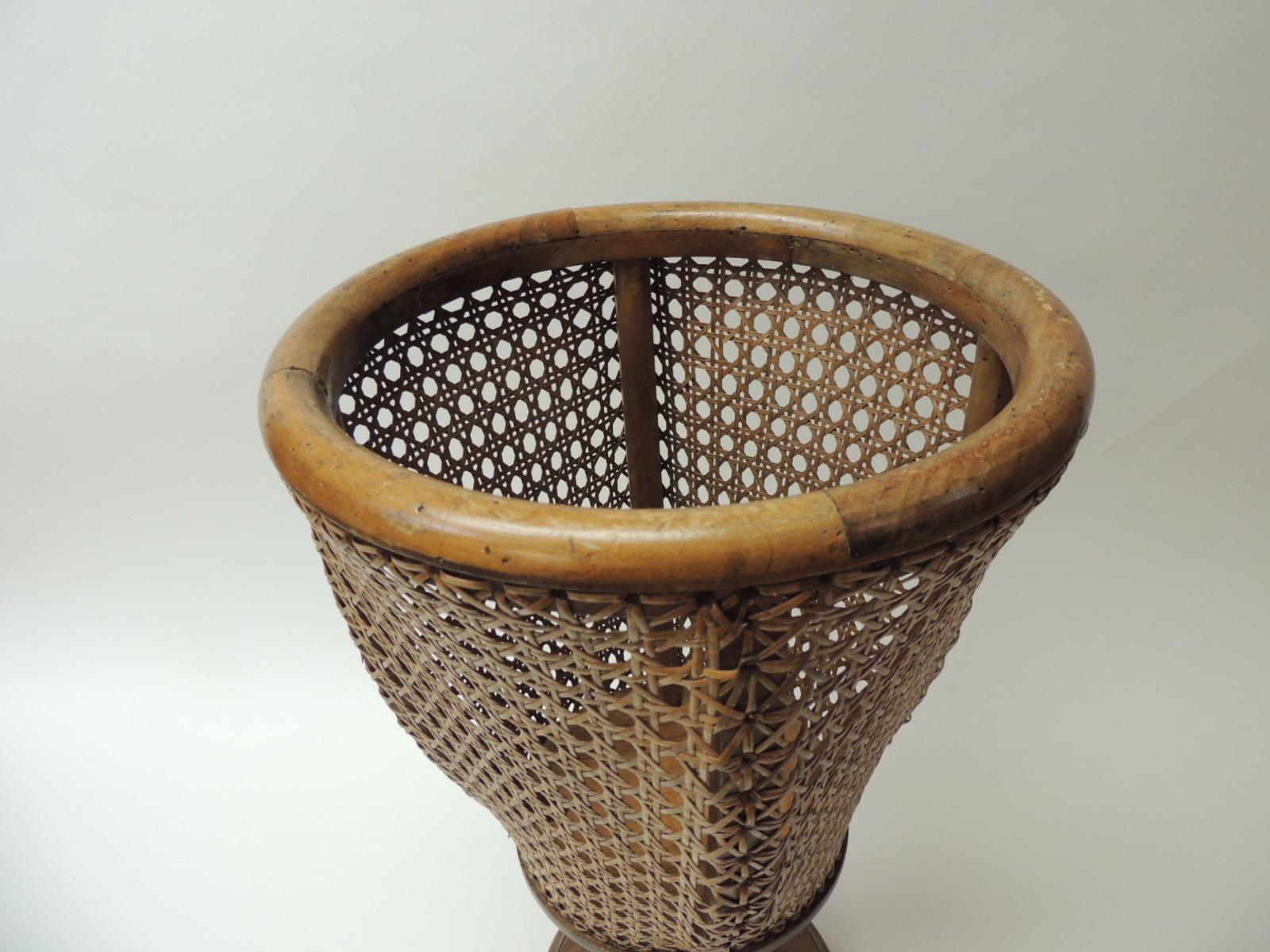 Vintage tall bent wood planter
Tall round footed vintage planter wood base and wicker caning all around.
Stamped, made in Italy 1983
Size: 12” D x 19.5” H
Base is 8” D.
 
