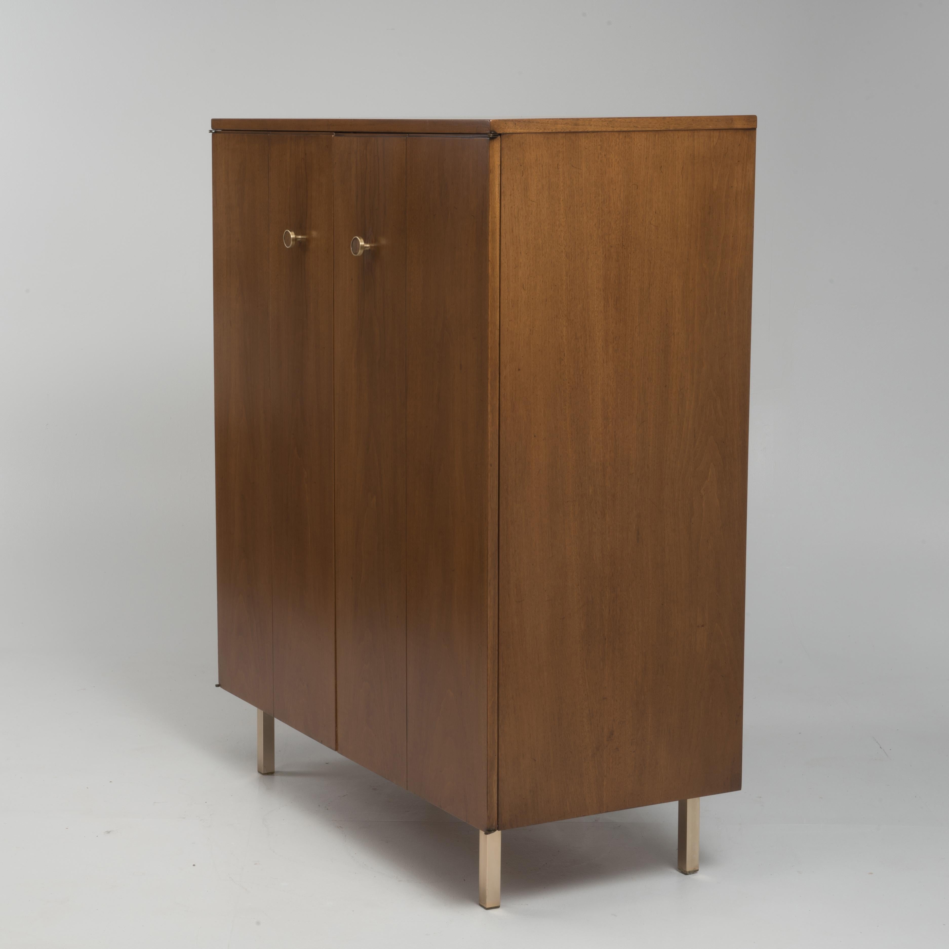 An elegant midcentury men's tall dresser by Johnson Furniture is a restored satin finish. We are attributing the piece to Paul Frankl. Incredibly well made with brass hardware and feet, piano hinges and excellent proportions. The four front panels