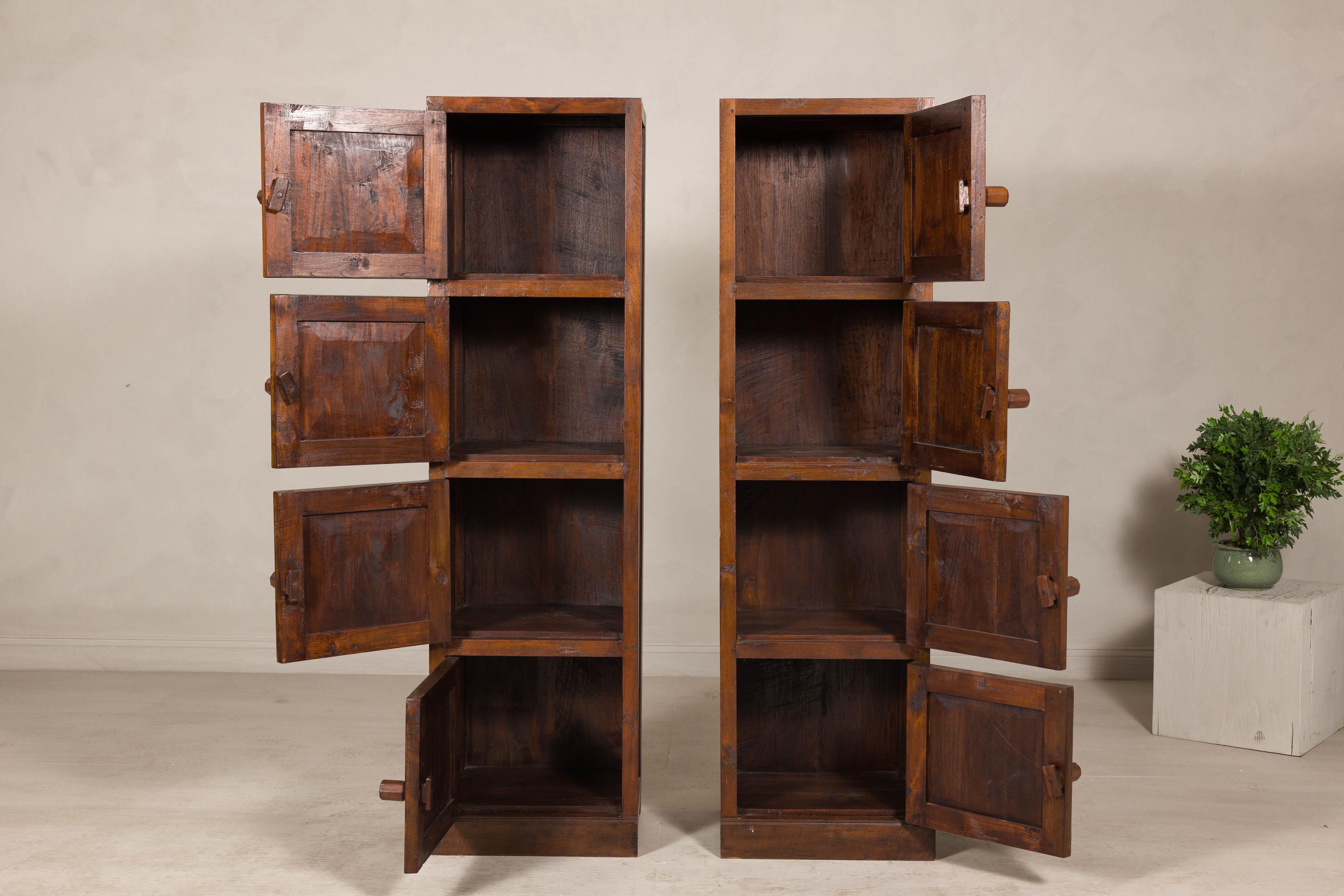 Una coppia di armadi alti e stretti in legno di teak. Questa coppia vintage di armadi alti e stretti, che unisce praticità e carattere, dona calore e fascino senza tempo a qualsiasi ambiente. Realizzato in legno di teak riccamente patinato, ogni