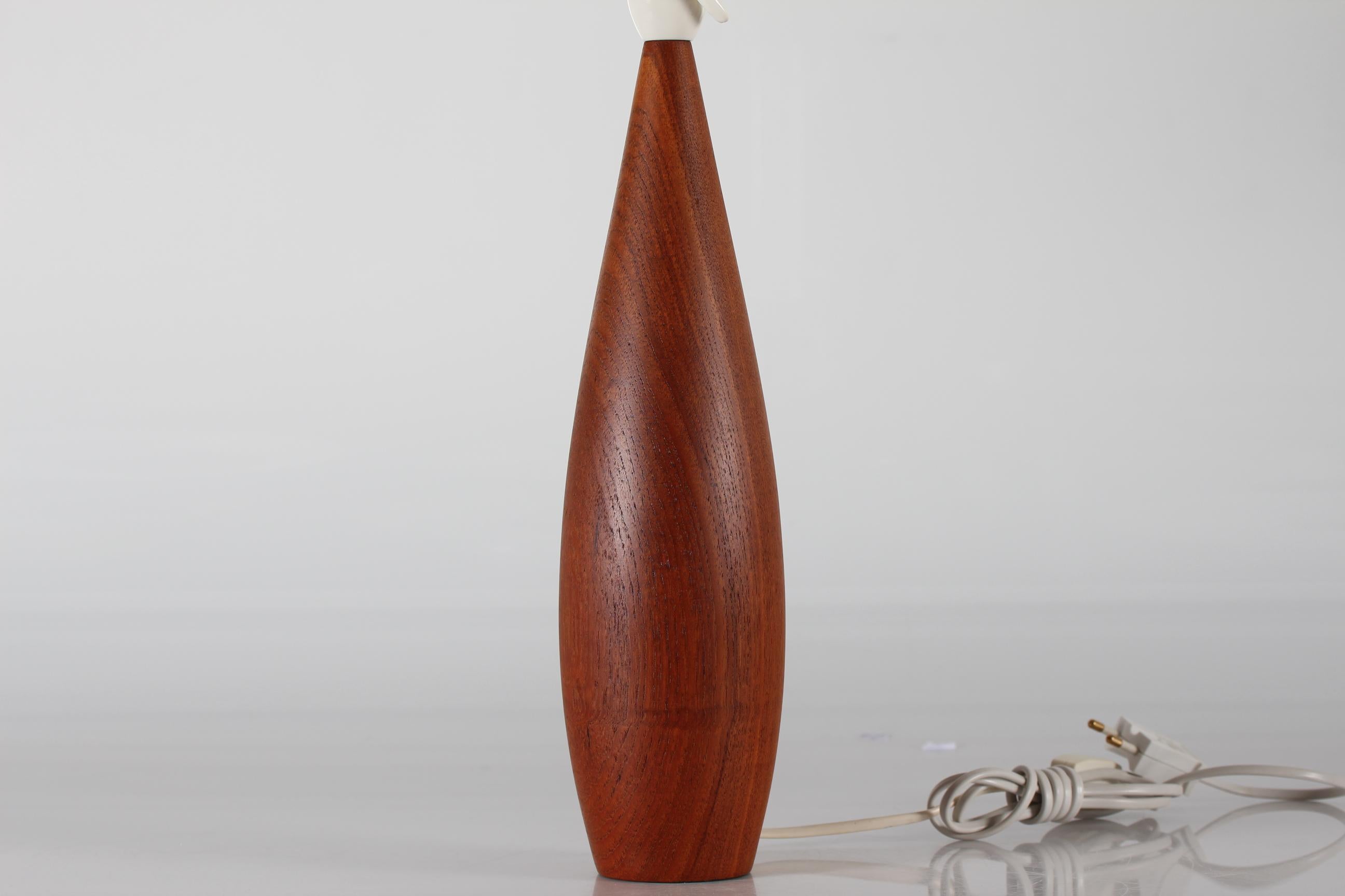 Scandinavian table lamp from the 1960s.
The tall and slender lamp foot is made of hand-turned solid teak and mounted with a new lampshade.

Measures: Height 60 cm
Height lamp foot only 36 cm
Diameter shade 32 cm.

Included is a new lamp shade