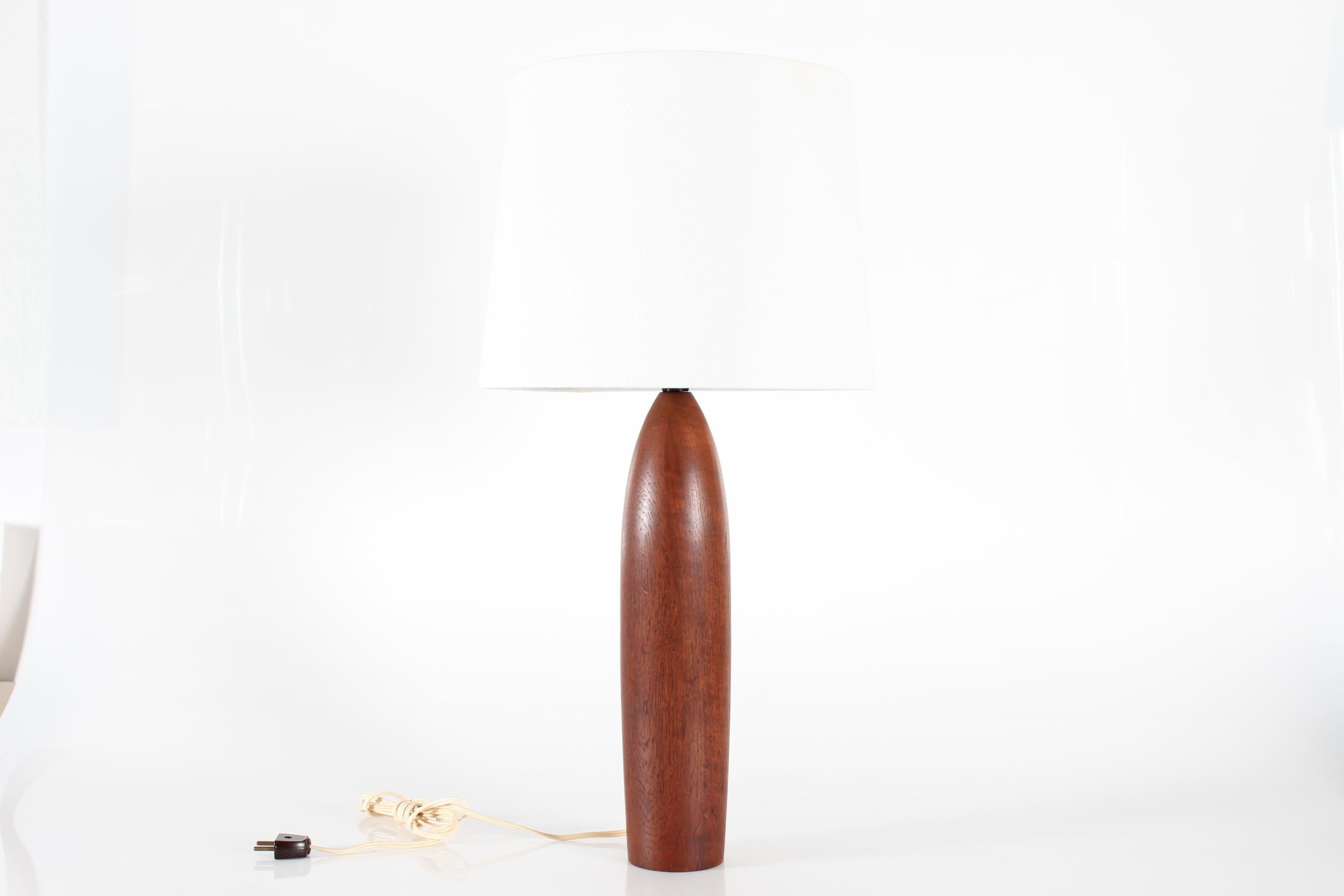 Tall and slender lamp base made of hand-turned solid teak mounted with a new lampshade.
Crafted by hand in Scandinavia in the 1960s, most likely in Denmark

Measures: Height 67 cm
Height lamp base only 40.5 cm
Diameter shade 34 cm
Diameter lamp base