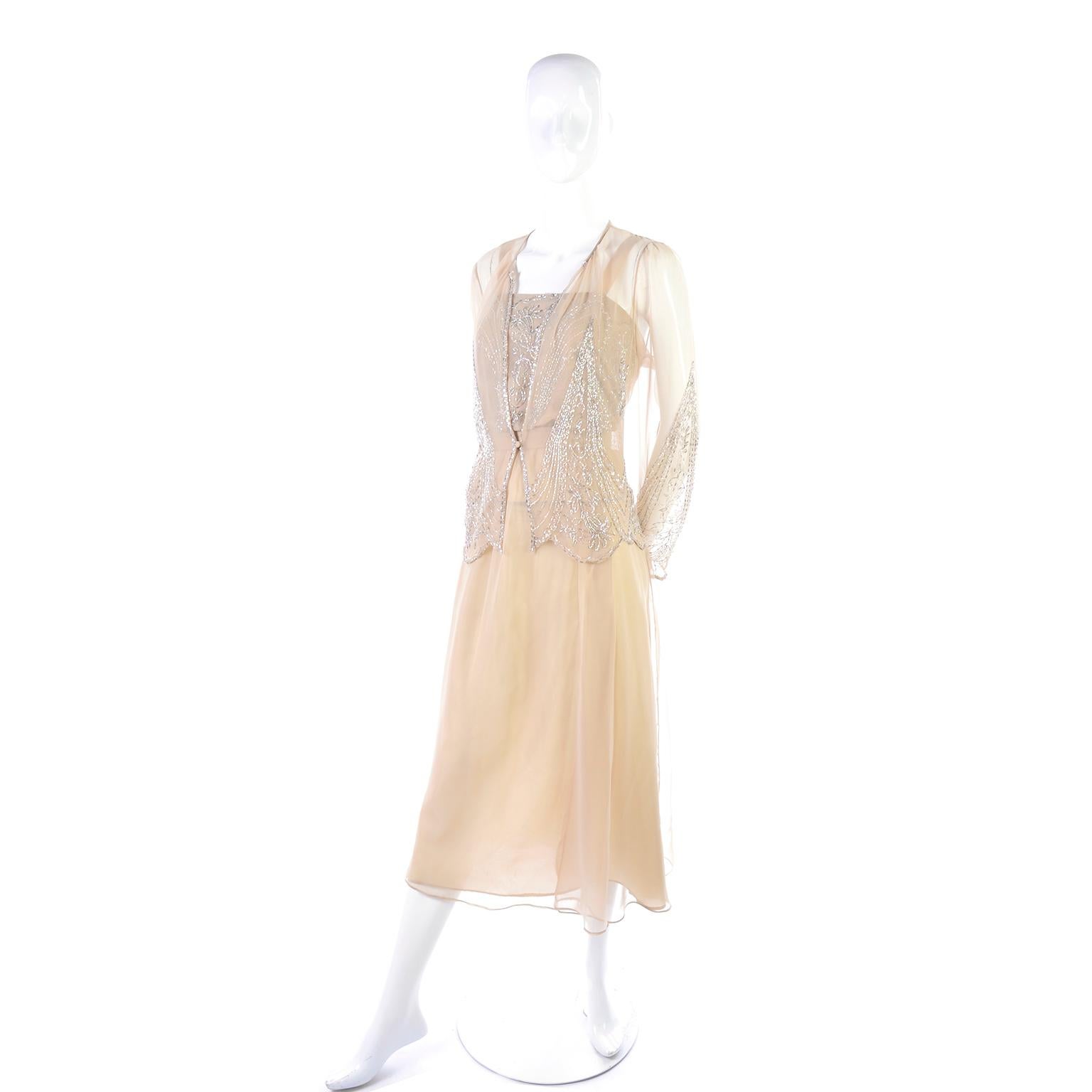 This is a gorgeous vintage Jack Bryan sand/tan colored dress with a sheer jacket. The dress is taffeta with a sheer chiffon overlay and sleeveless with beautiful beading on the bodice and an elastic waist. There is a belt that secures with hook and