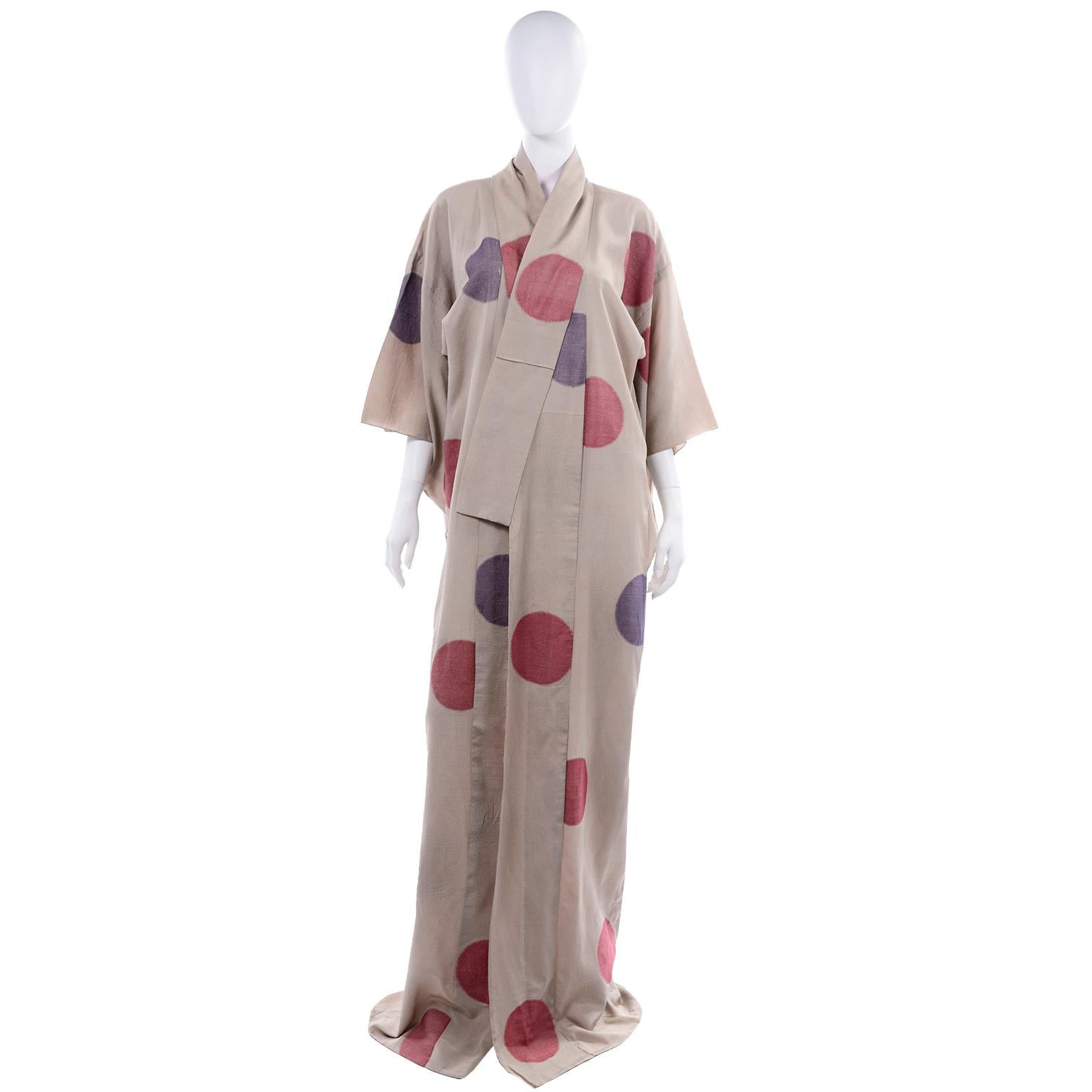 We love vintage kimonos and this is a really wonderful one! This  tan kimono has red and purple lamé circles or dots throughout. This raw silk kimono has pink silk lining at the top of the collar and on the lapels. There is an orange stitch in the