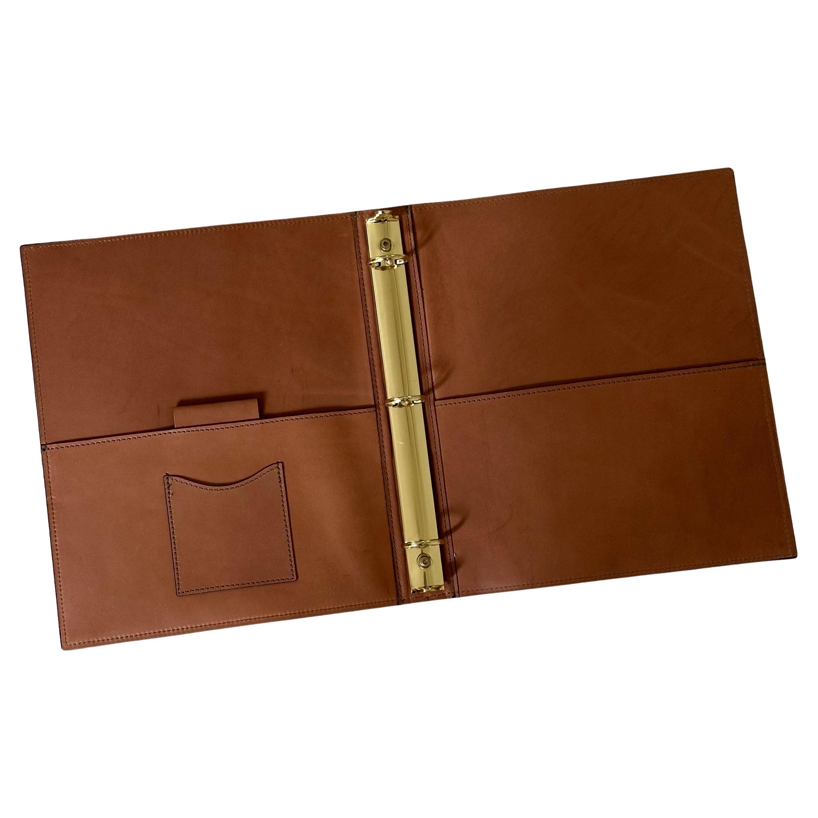 Vintage tan leather three ring binder by Hartmann, circa 1980s.  The binder is in like new condition and has never been used; it measures 10