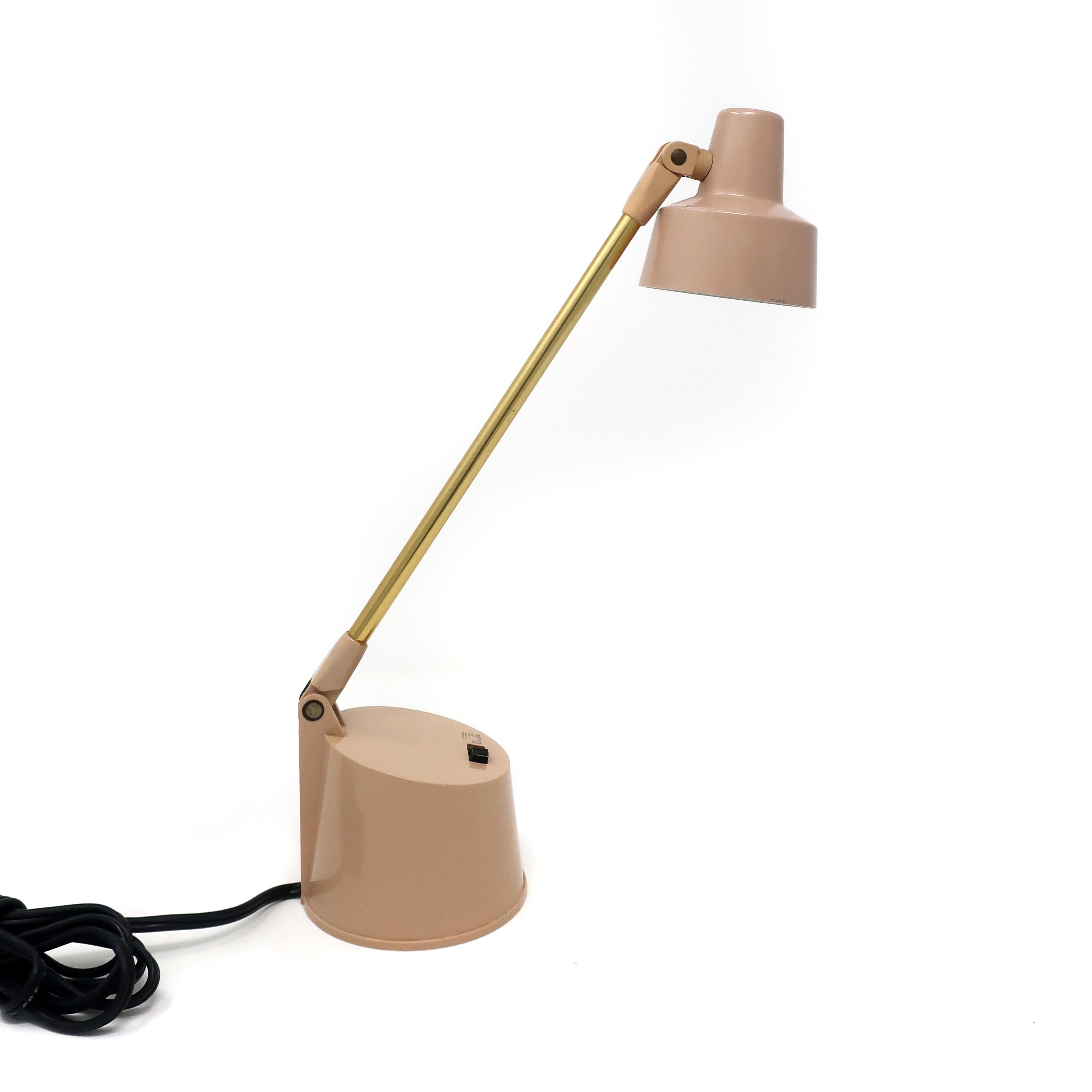 A vintage tensor lamp with a tan midcentury metal shade and base and brass stem. Can be set on a desk or, using holes in base, mounted to a wall.

Marked on base and includes label on bottom. In good vintage condition with wear consistent with age