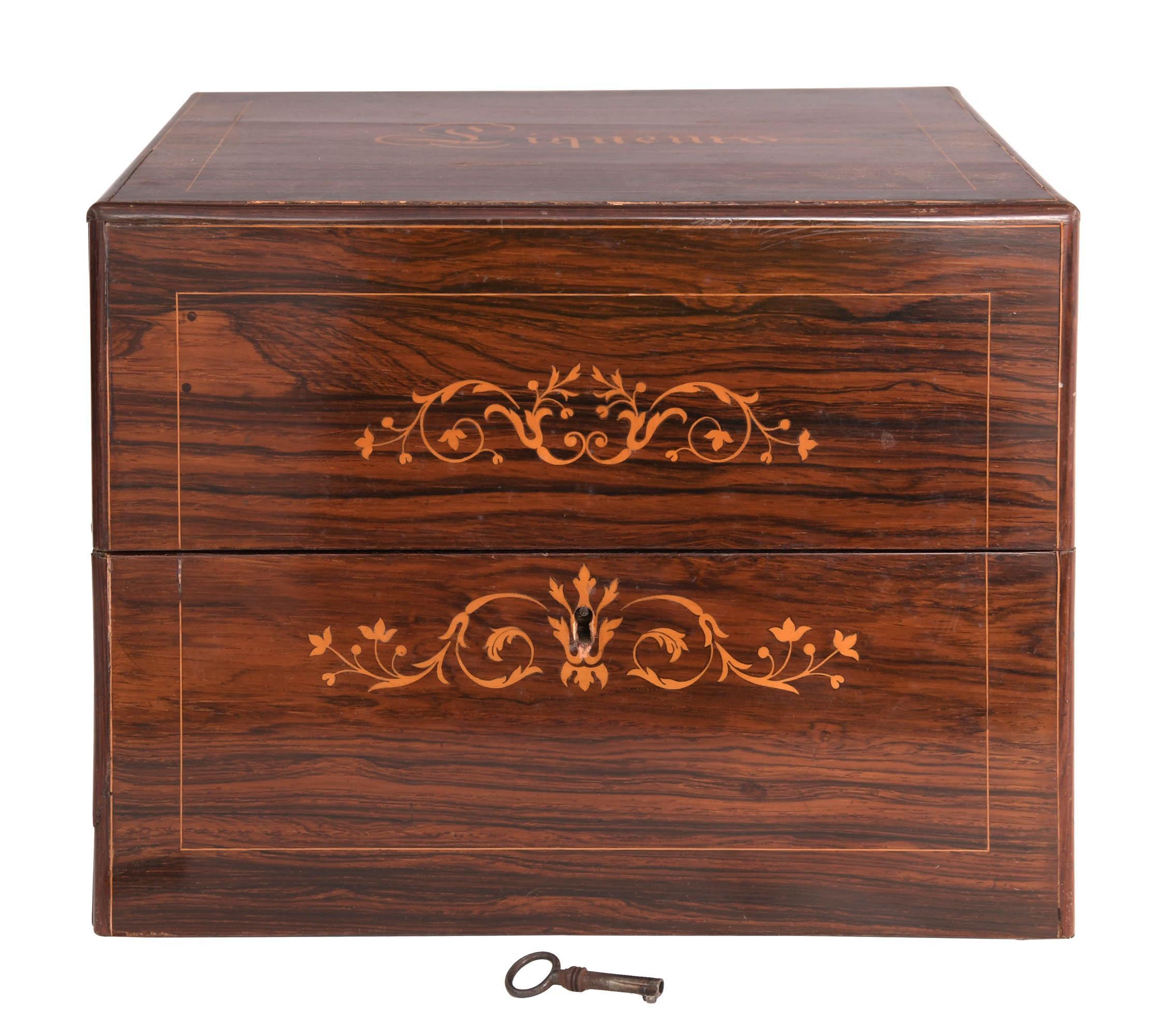 Presented is an exquisite French Napoleon III-period “Cave à Liqueur”, or tantalus, in rich rosewood. This elegant bar set opens by means of a hinged lid, inlaid with “Liqueurs” at top, to reveal a fitted interior, complete with its set of four cut