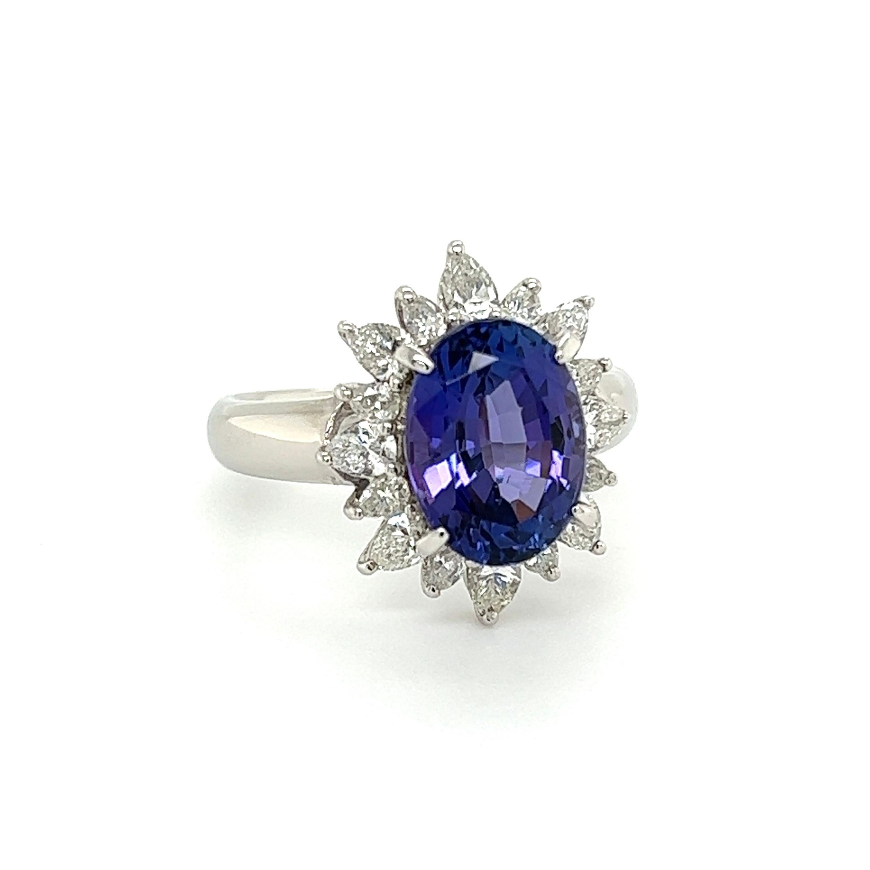 Simply Beautiful! Finely detailed Tanzanite and Diamond Platinum Halo Ring. Centering a securely nestled Hand set Oval 4.00 Carat Tanzanite, surrounded by Pear Diamonds, weighing approx. 1.02tcw, including shank. Hand crafted Platinum mounting.
