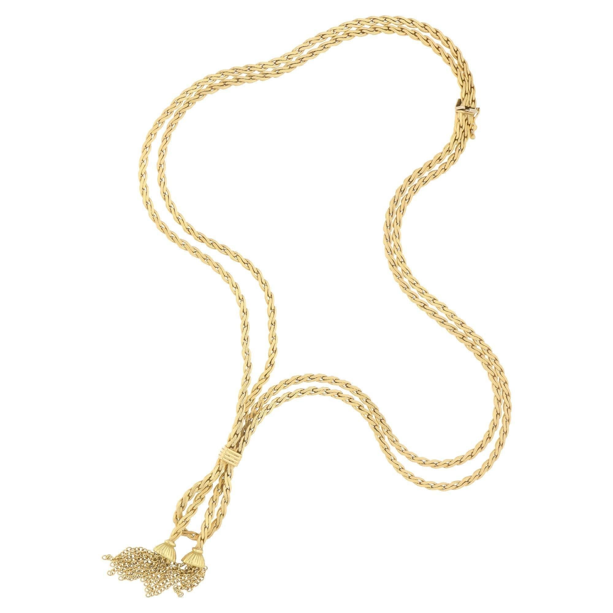 A lovely vintage tassel necklace set in 18k yellow gold.

This necklace has been beautifully hand crafted and features two strands of solid 18k yellow gold chain. Both chains hang elegantly and meet in the center of the neck where they are secured